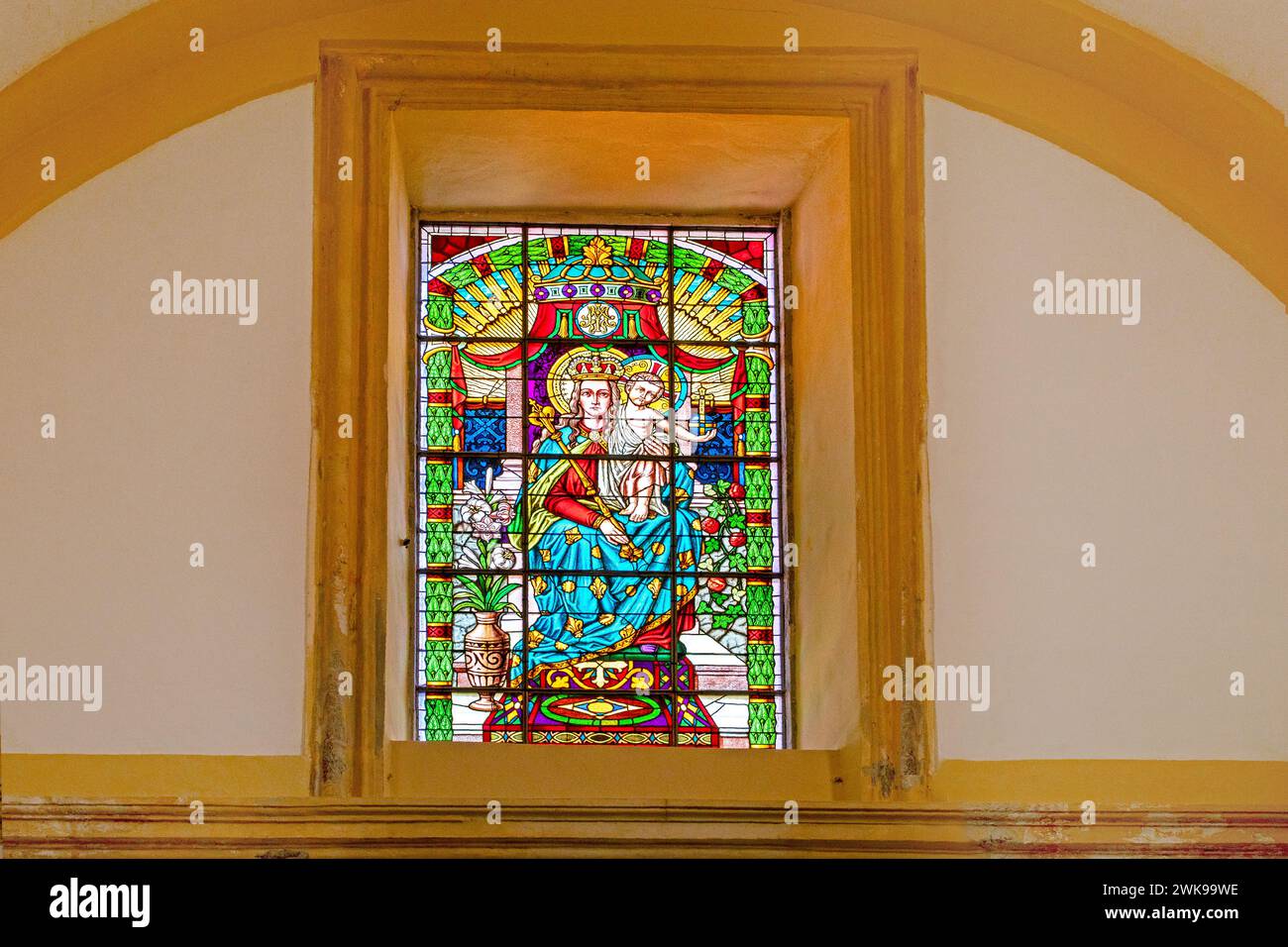 stained glass rectangular window with the Mother of God and little Jesus in a small church