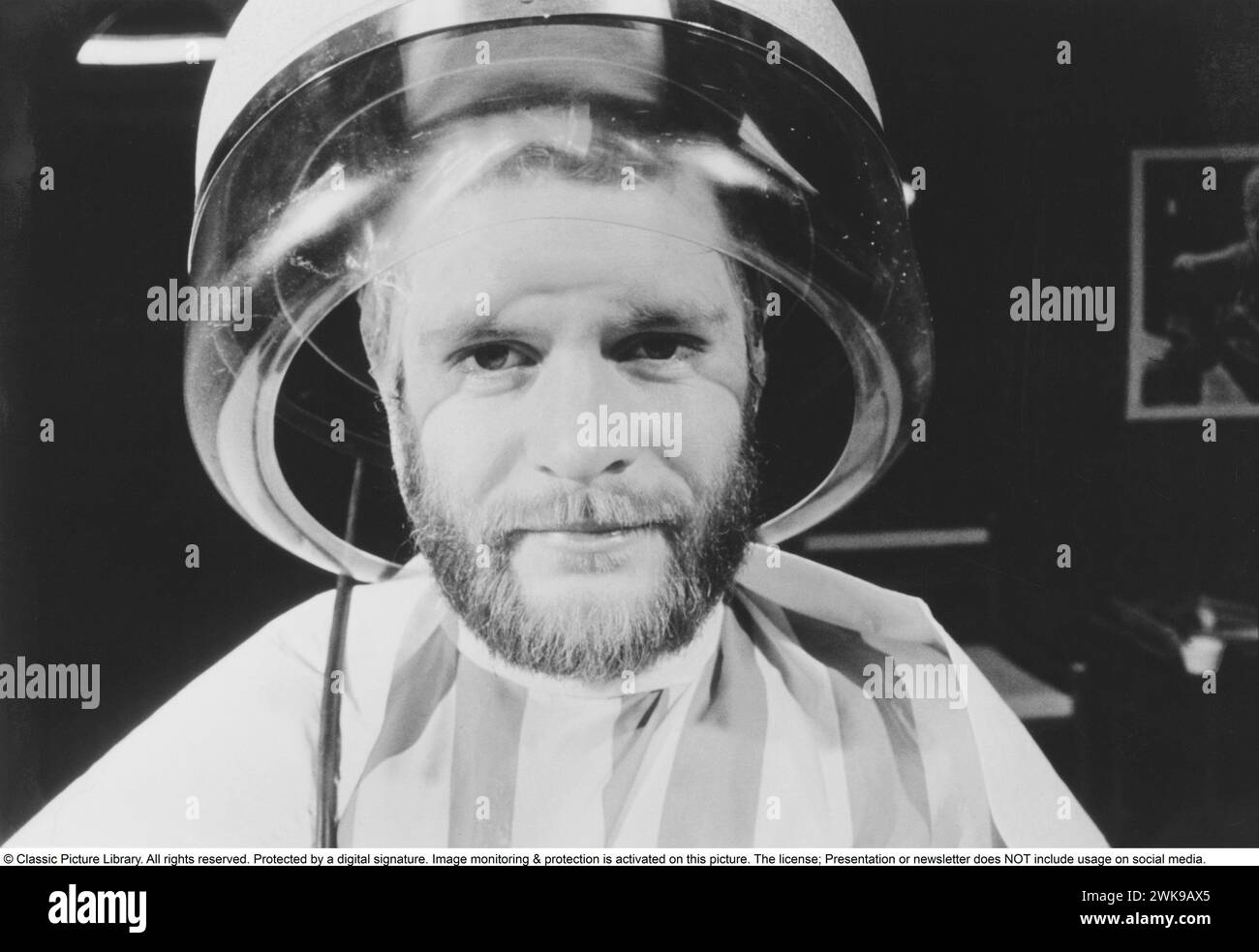 under-the-hair-dryer-1976-a-man-is-sitting-comfortably-drying-his-hair