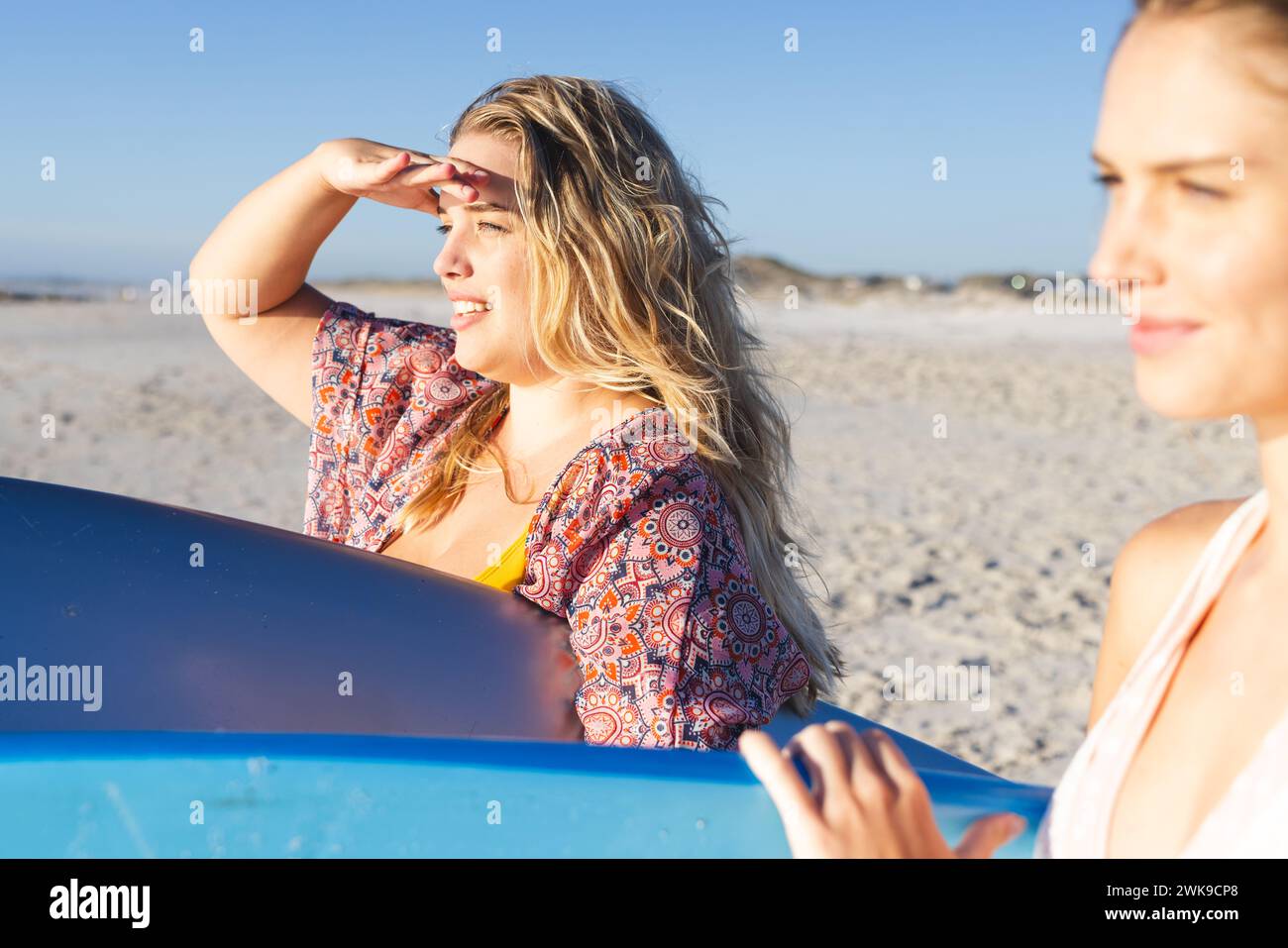 Two young Caucasian women enjoy a sunny beach day Stock Photo