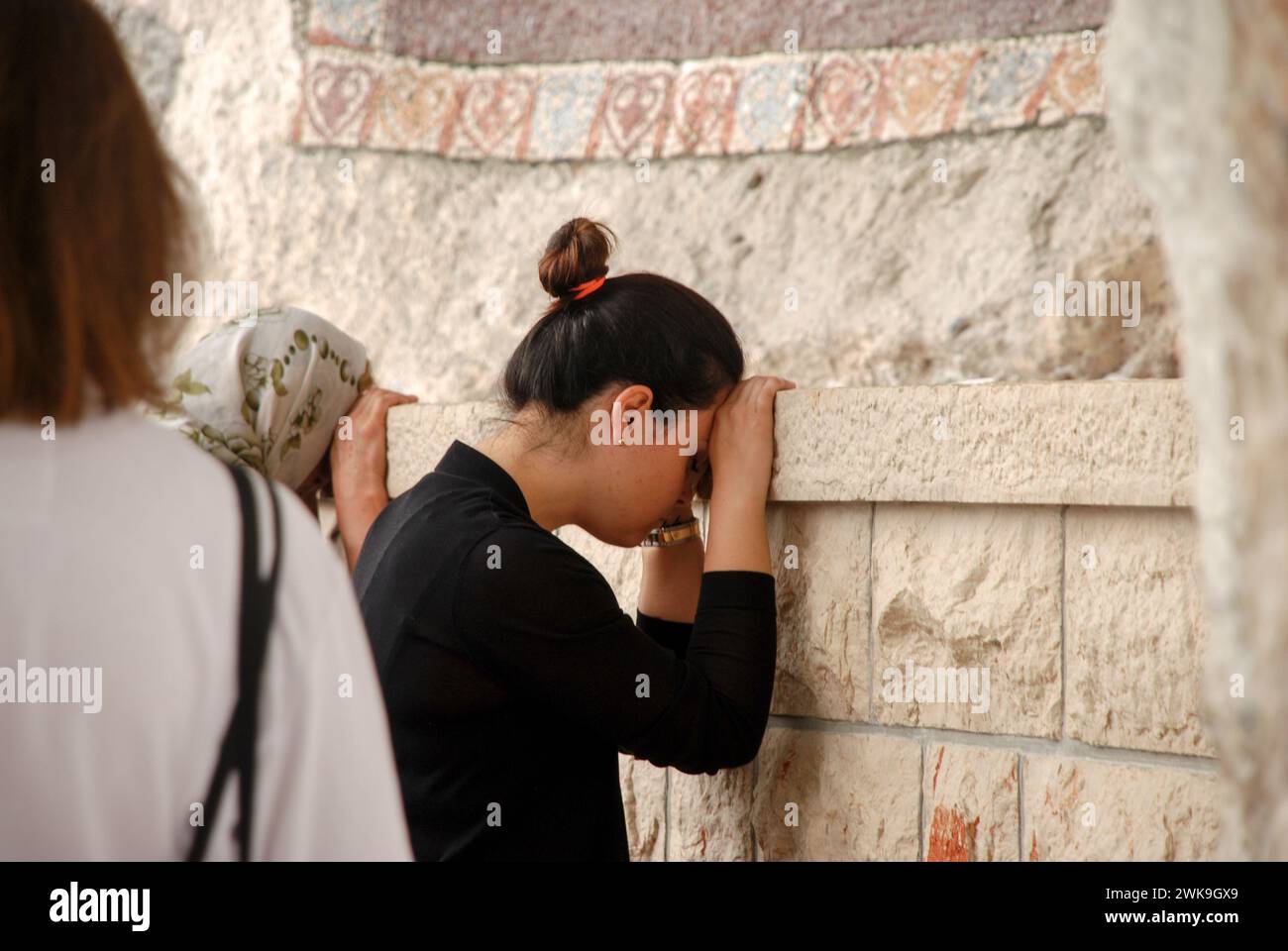Woman praying to God. Pilgrim in front of an icon. A woman rested her ...
