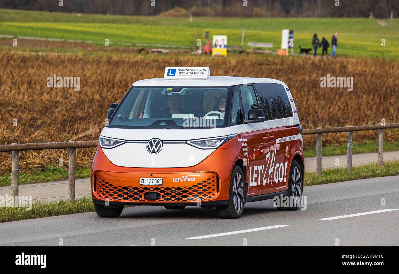 Ein VW ID. Buzz fährt, als Fahrschulauto, auf einer Strasse