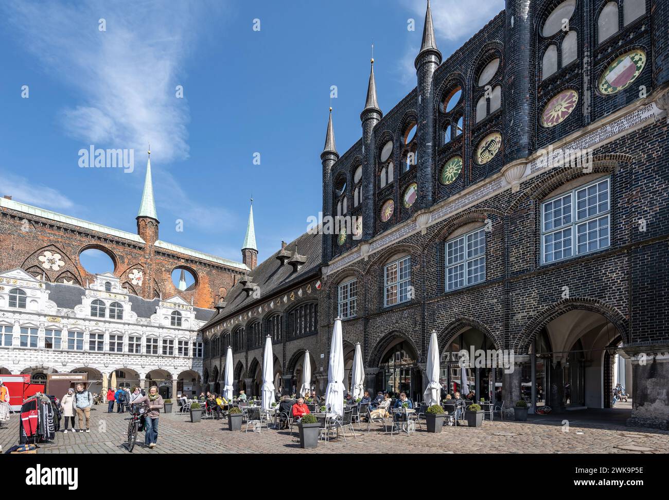Lubeck, Germany, April 17, 2023: Market place surrounded by Lubeck town hall buildings in different architecture styles, city life with street café an Stock Photo