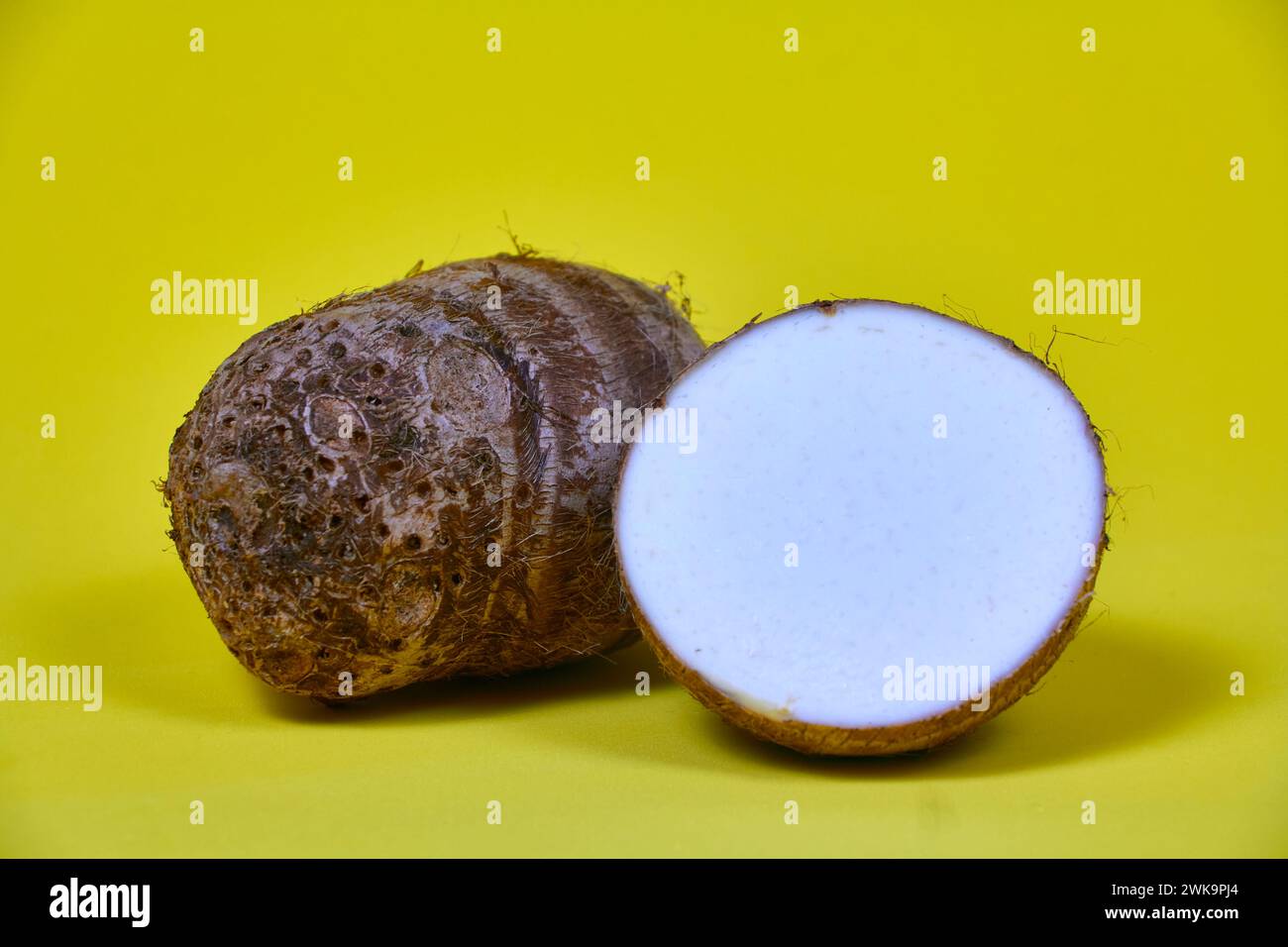 closeup of taro root vegetable, eddo malanga, yellow background Stock Photo