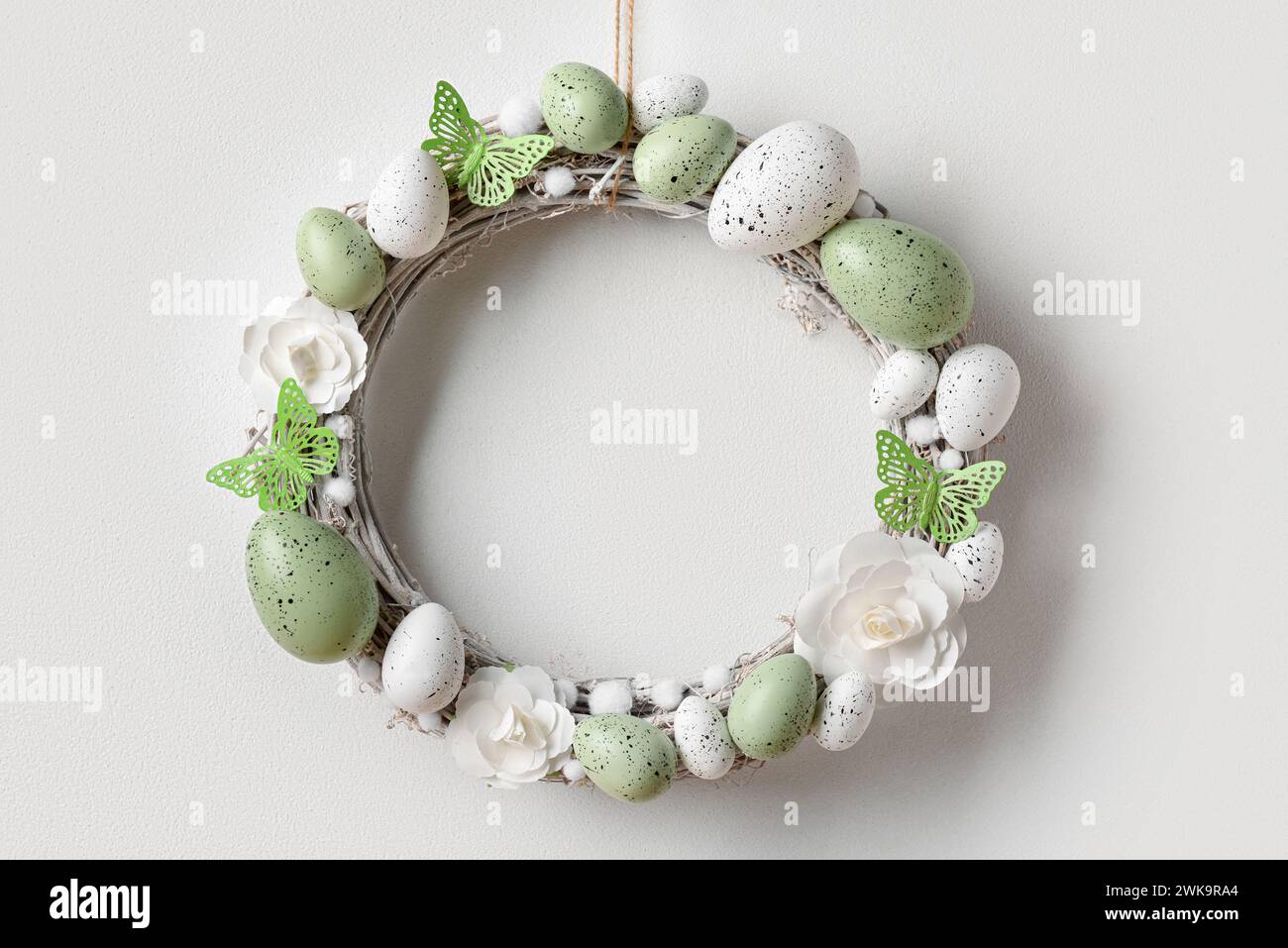 Easter wreath made of flowers, eggs and butterflies with branches ...