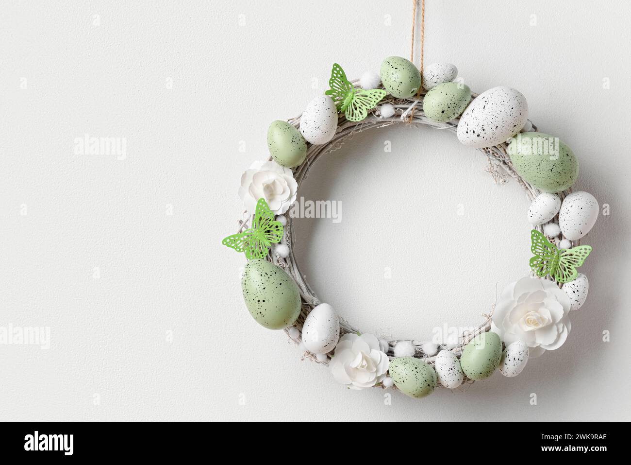 Easter wreath made of flowers, eggs and butterflies with branches ...