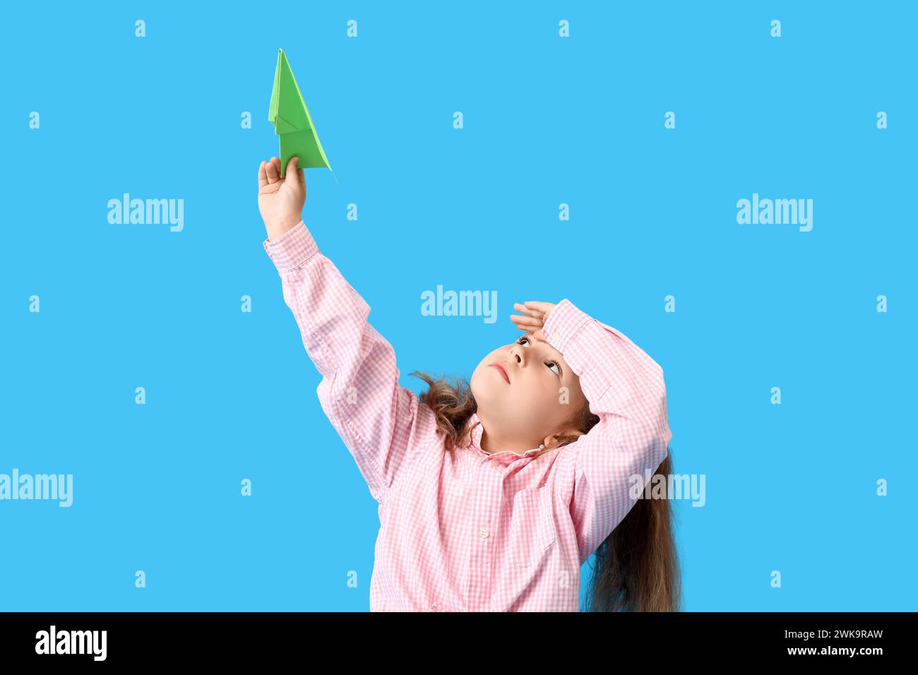 Cute little girl with paper plane on blue background Stock Photo - Alamy