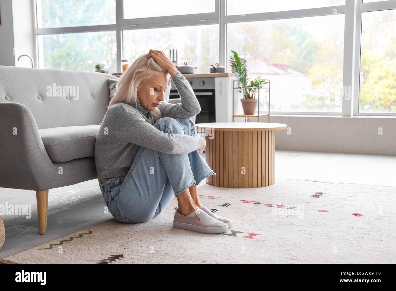 Mature woman sitting on floor at home hi-res stock photography and ...