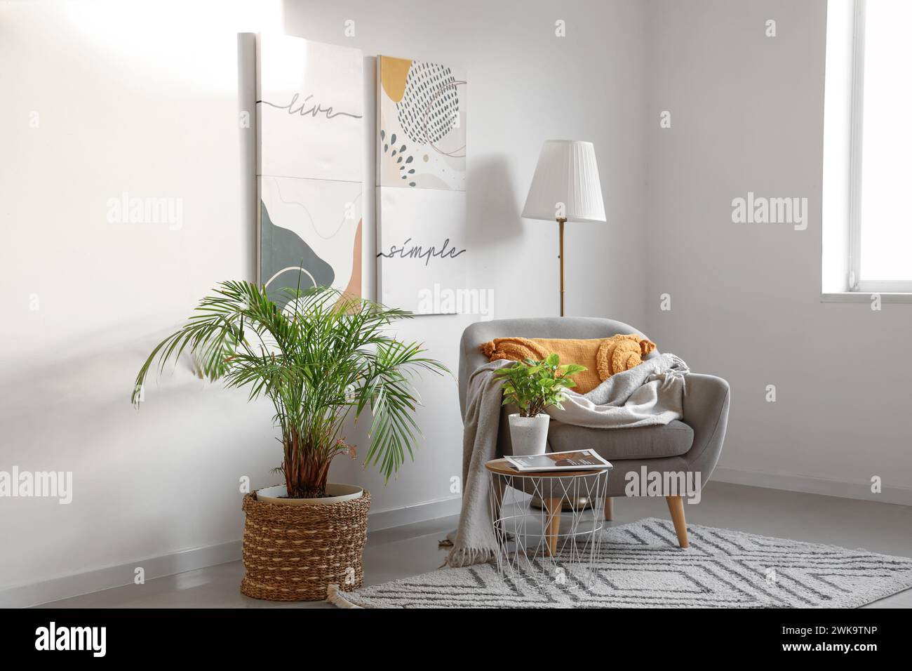 Interior of light living room with armchair, lamp and paintings Stock ...