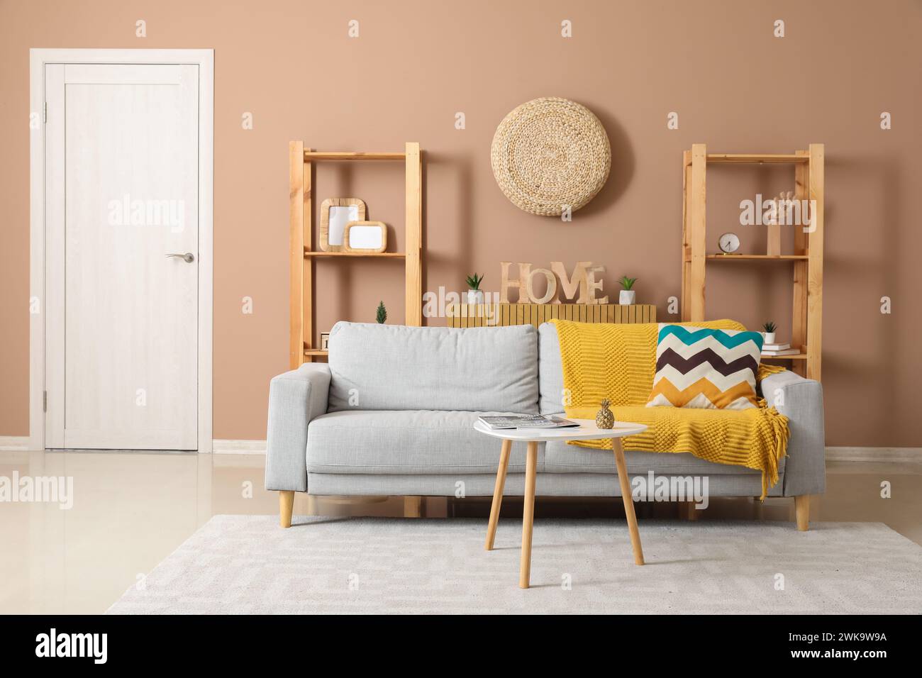 Interior of stylish living room with grey sofa, table and shelf units ...