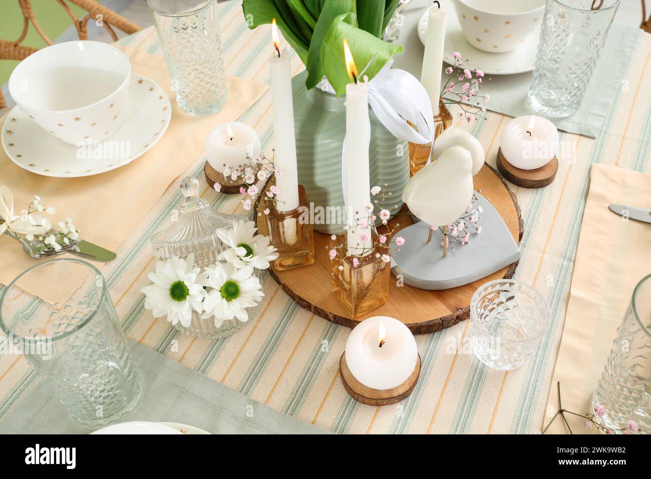 Beautiful table setting with burning candles and flowers for ...
