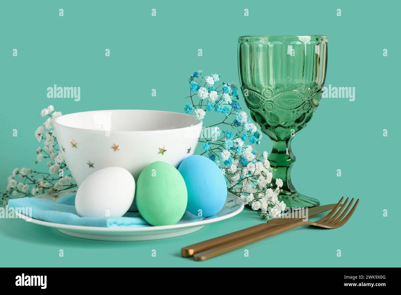 Beautiful table setting for Easter with eggs and flowers on turquoise ...