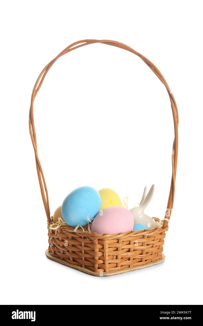 Wicker basket with painted Easter eggs and ceramic bunny on white ...