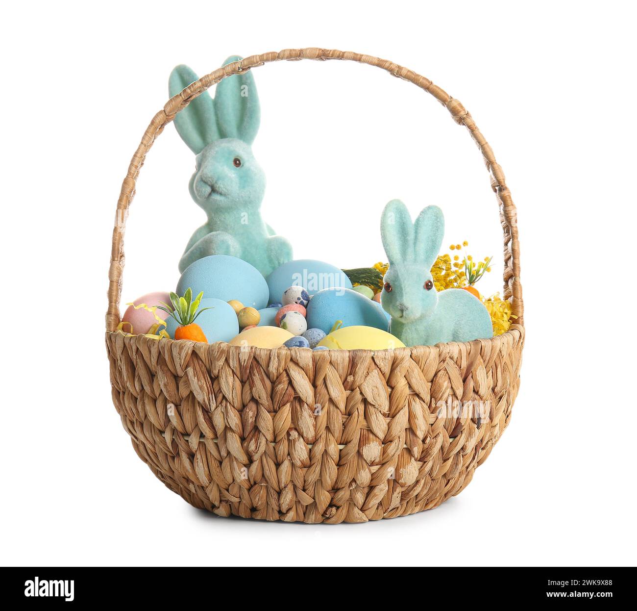Wicker basket with painted Easter eggs and toy bunnies on white ...
