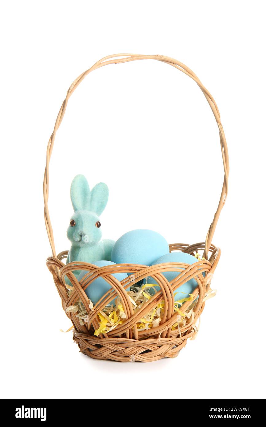 Wicker basket with painted Easter eggs and toy bunny on white ...