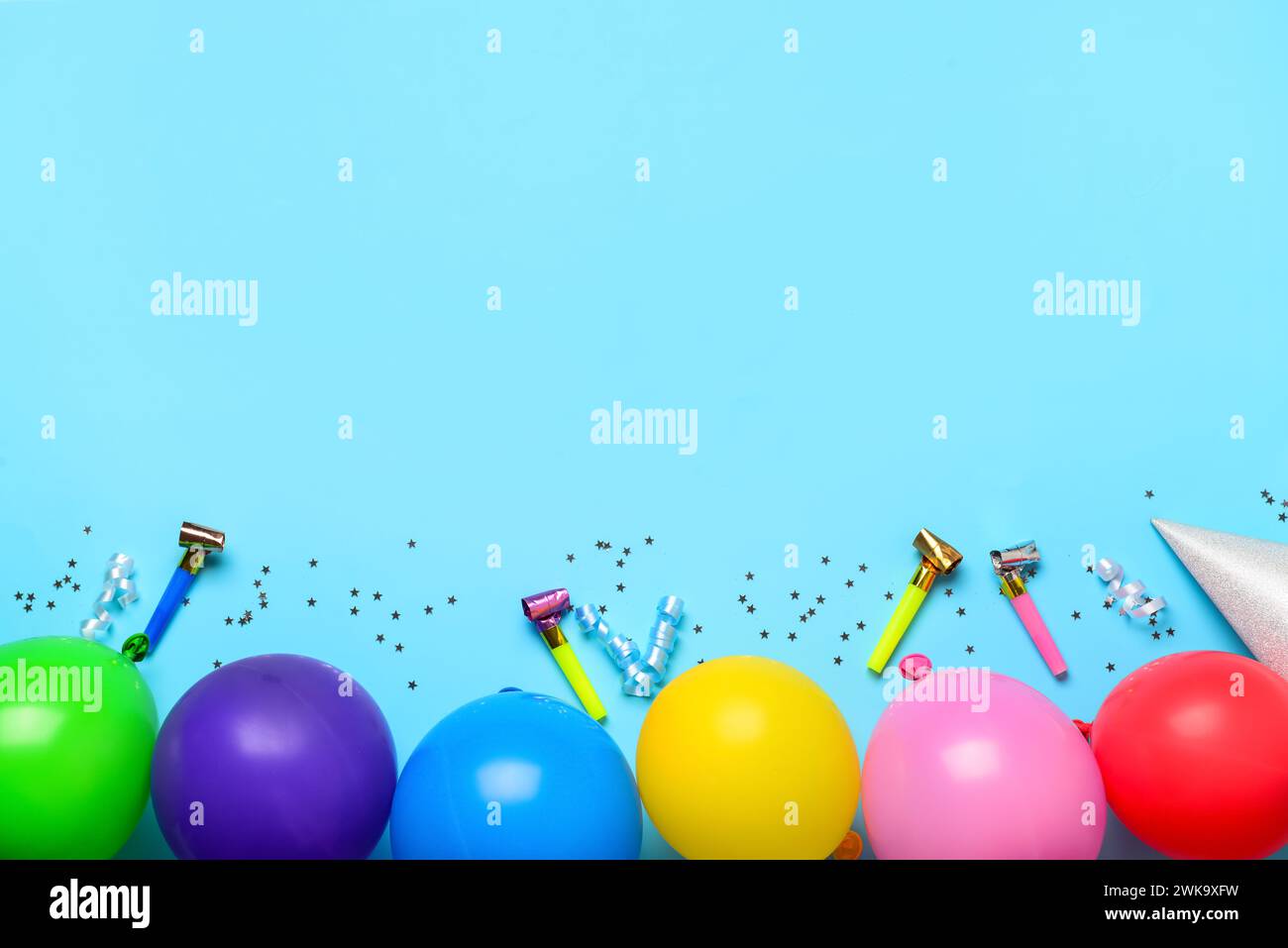 Colorful balloons, confetti and party horns on blue background Stock ...
