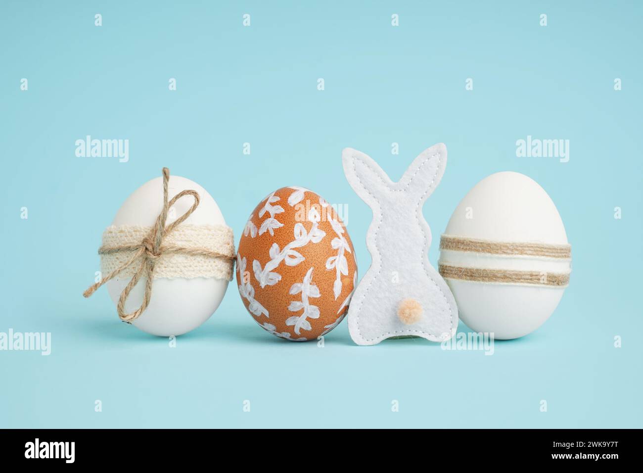 Decorated Easter eggs and fabric bunny on blue background Stock Photo