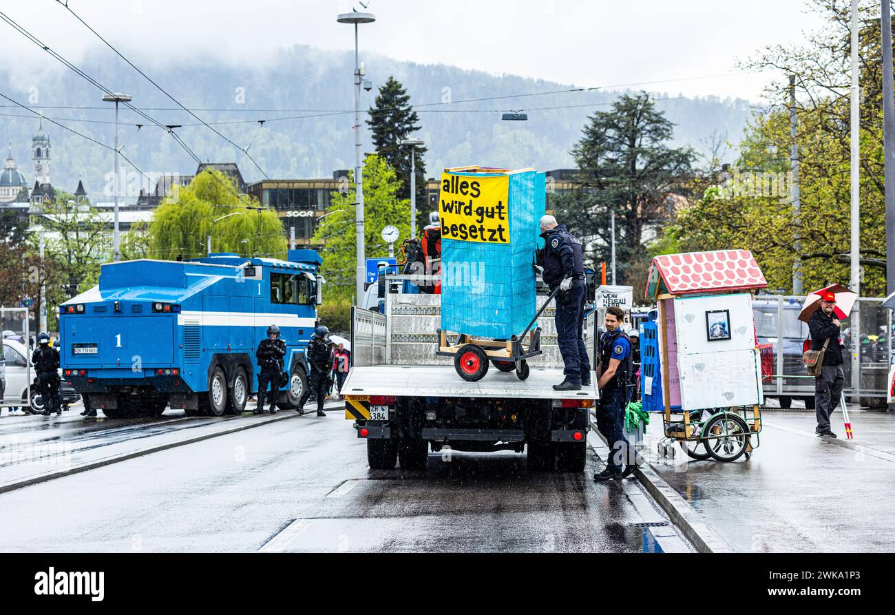 Zürcher Stadtpolizisten laden Anhänger von Demonstranten auf einen Lastwagen auf. (Zürich, Schweiz, 1. Mai 2023) Stock Photo