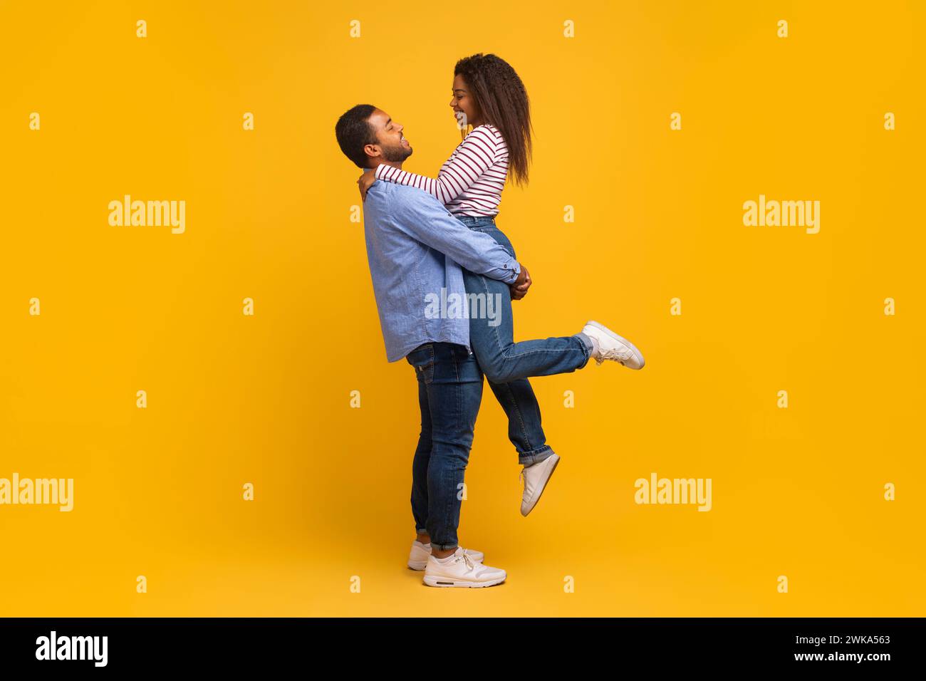 Side view of romantic young black man holding and hugging his ...