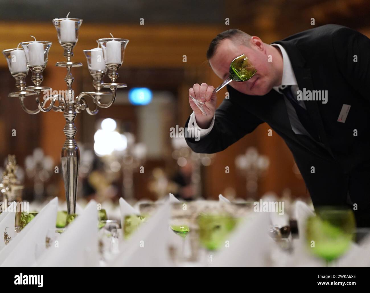 Hamburg, Germany. 19th Feb, 2024. Martin Gansen, Head of Event Services and Event Management Landesbetrieb Rathausservice, checks the glasses during the final preparations for the traditional Matthiae meal of the Hamburg Senate in the large banquet hall in City Hall. The Prime Minister of the Republic of Estonia Kallas and Federal Chancellor Scholz are expected to attend the Matthiae meal as guests of honor. The Matthiae banquet is considered to be the oldest still celebrated banquet in the world. Credit: Marcus Brandt/dpa/Alamy Live News Stock Photo