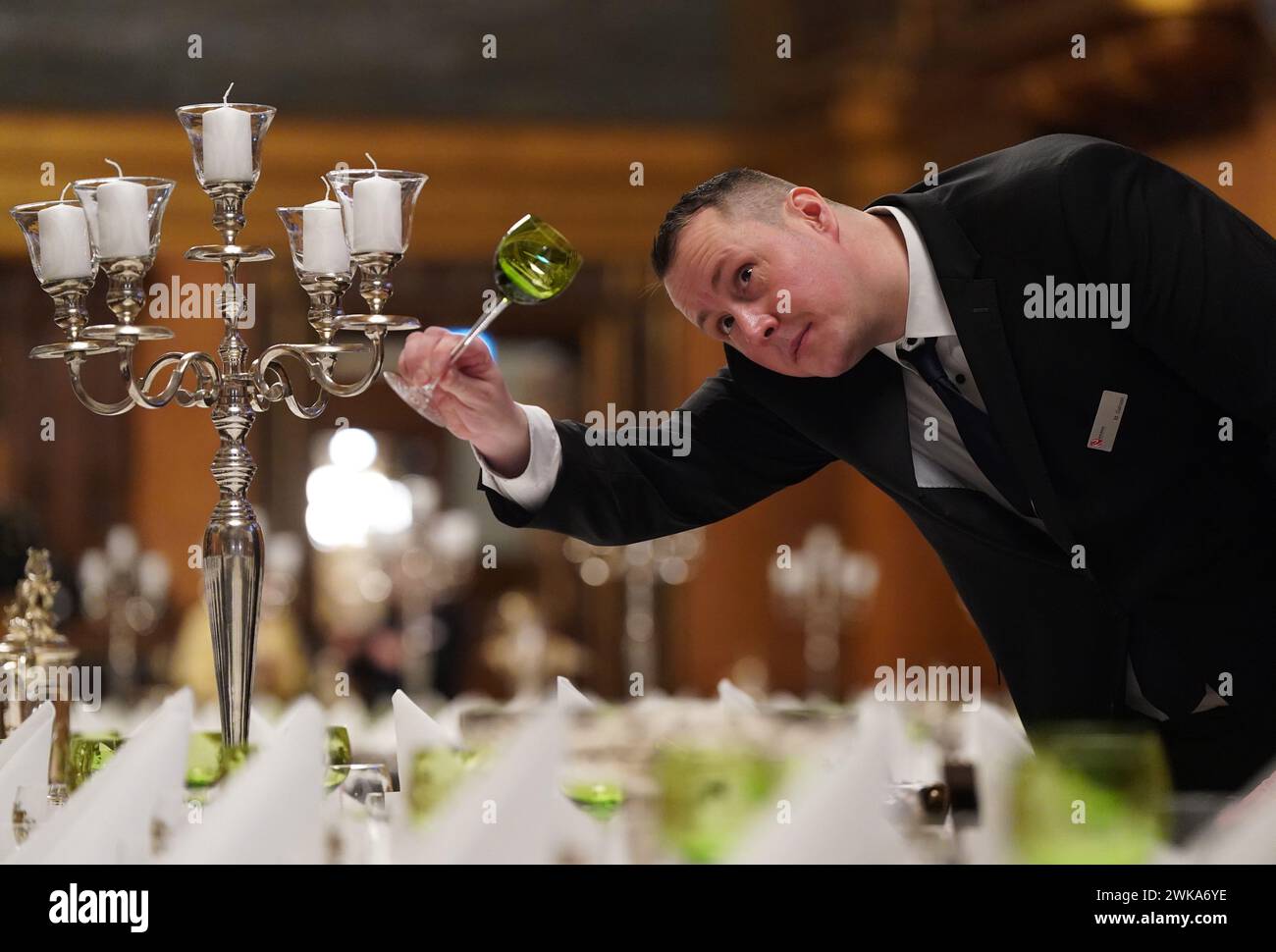 Hamburg, Germany. 19th Feb, 2024. Martin Gansen, Head of Event Services and Event Management Landesbetrieb Rathausservice, checks the glasses during the final preparations for the traditional Matthiae meal of the Hamburg Senate in the large banquet hall in City Hall. The Prime Minister of the Republic of Estonia Kallas and Federal Chancellor Scholz are expected to attend the Matthiae meal as guests of honor. The Matthiae banquet is considered to be the oldest still celebrated banquet in the world. Credit: Marcus Brandt/dpa/Alamy Live News Stock Photo