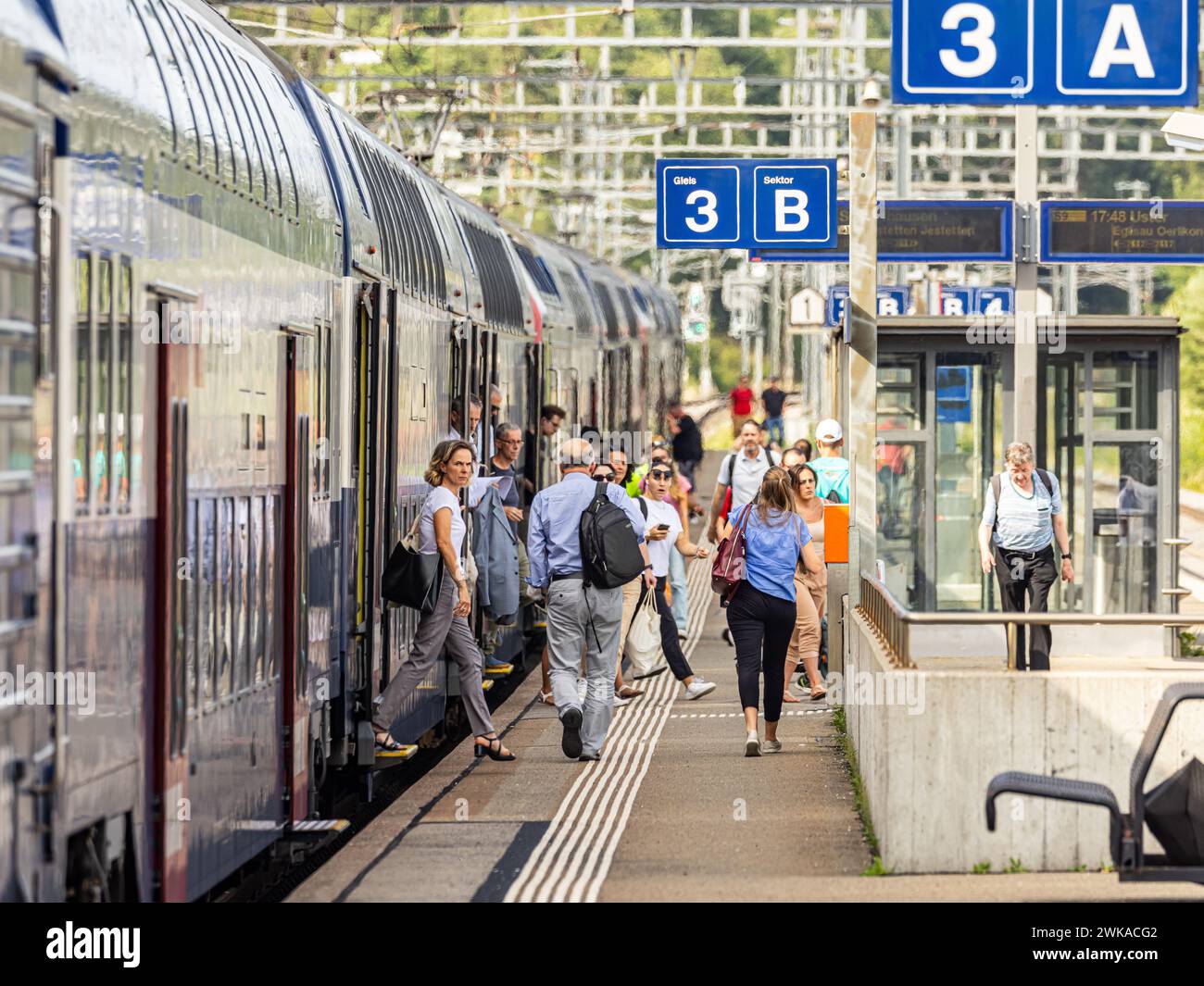 Reisende steigen aus der Zürcher S-Bahn Linie S9 (SBB Re 450) am Zürcher Bahnhof Hüntwangen-Wil aus.  (Hüntwangen, Schweiz, 17.07.2023) Stock Photo