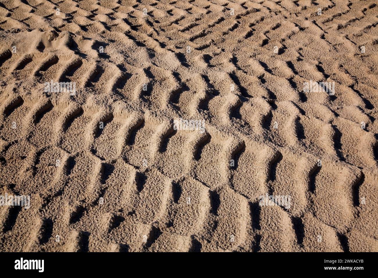 Close-up of heavy tire tracks in tan coloured sand at a sandpit, Quebec, Canada Stock Photo