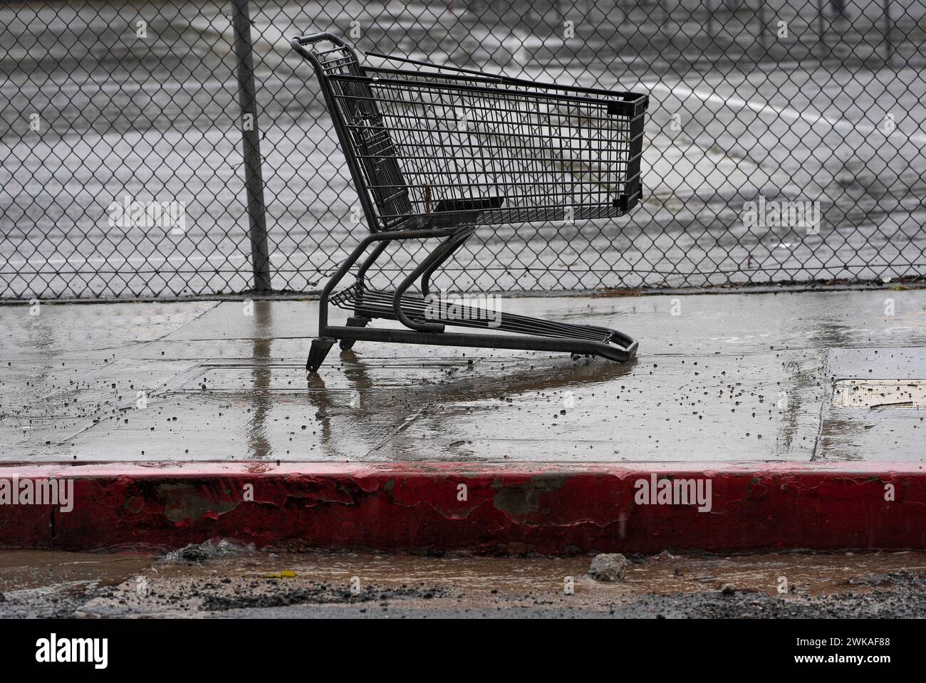 A shopping cart without wheels sits in the heavy rain in Los Angeles, Monday, Feb. 19, 2024. (AP