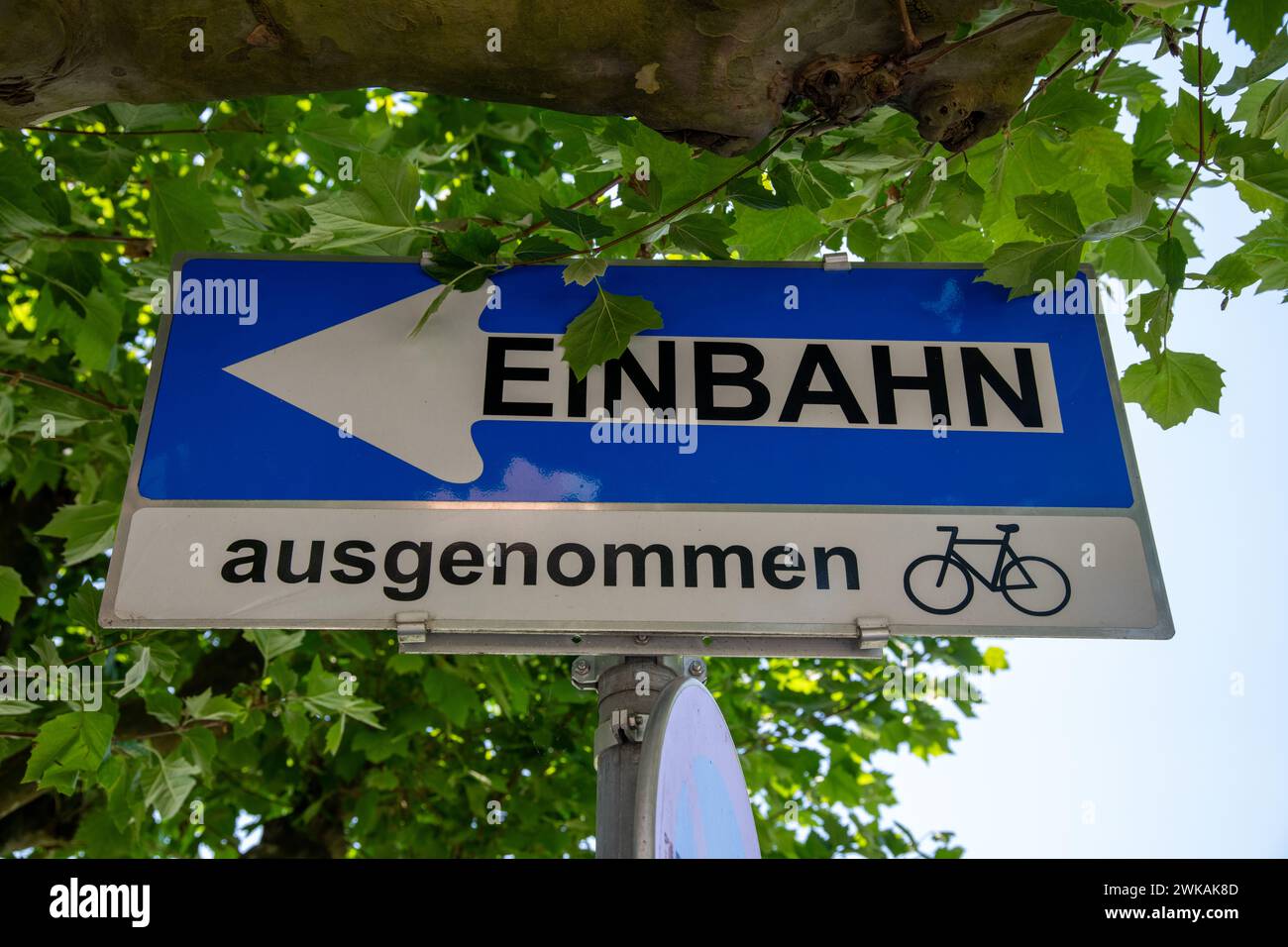 A blue and white sign with an arrow pointing to the left which means