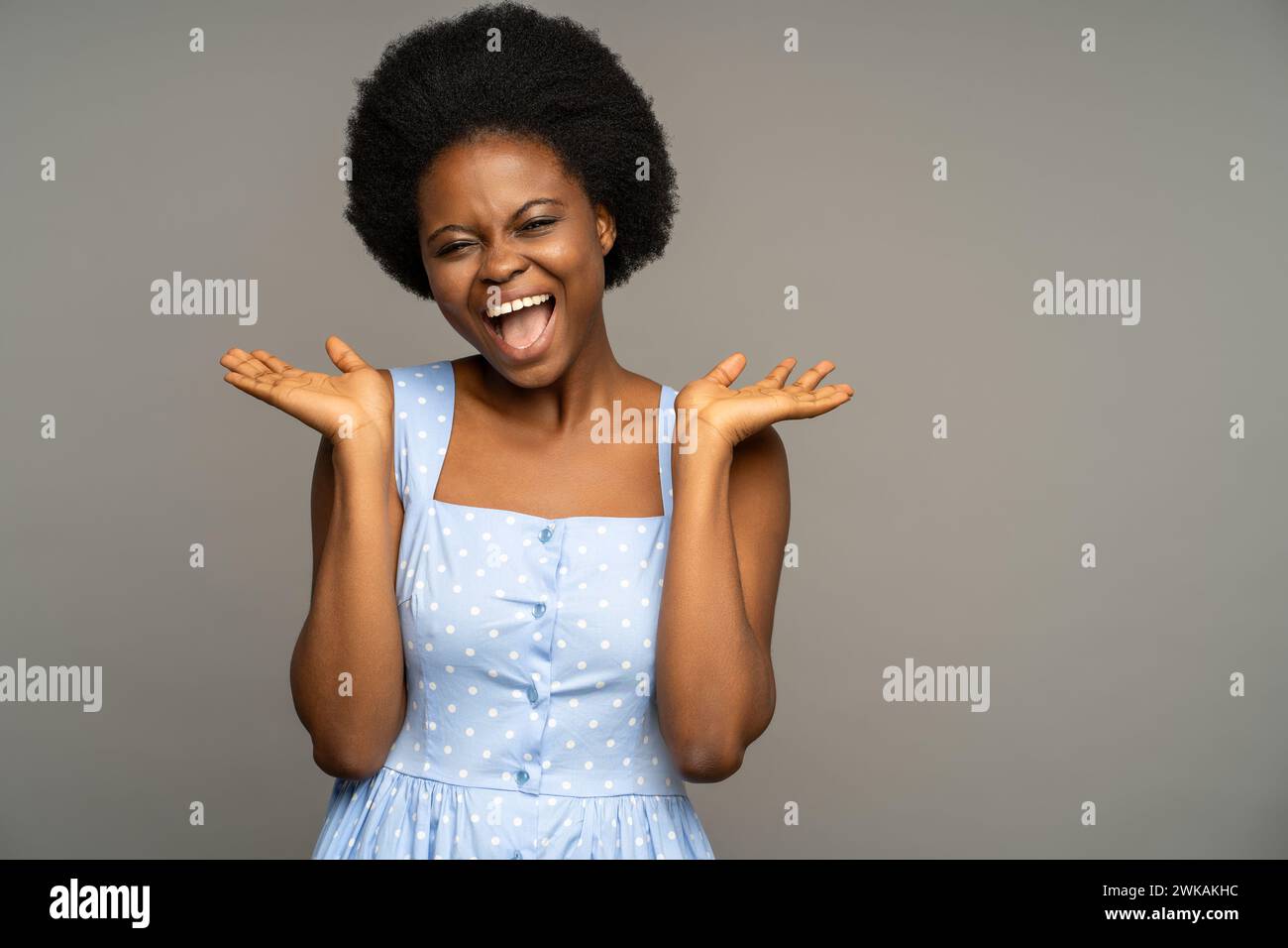 Overjoyed black female smiling, laughing broadly of great joy happiness, isolated grey background. Stock Photo