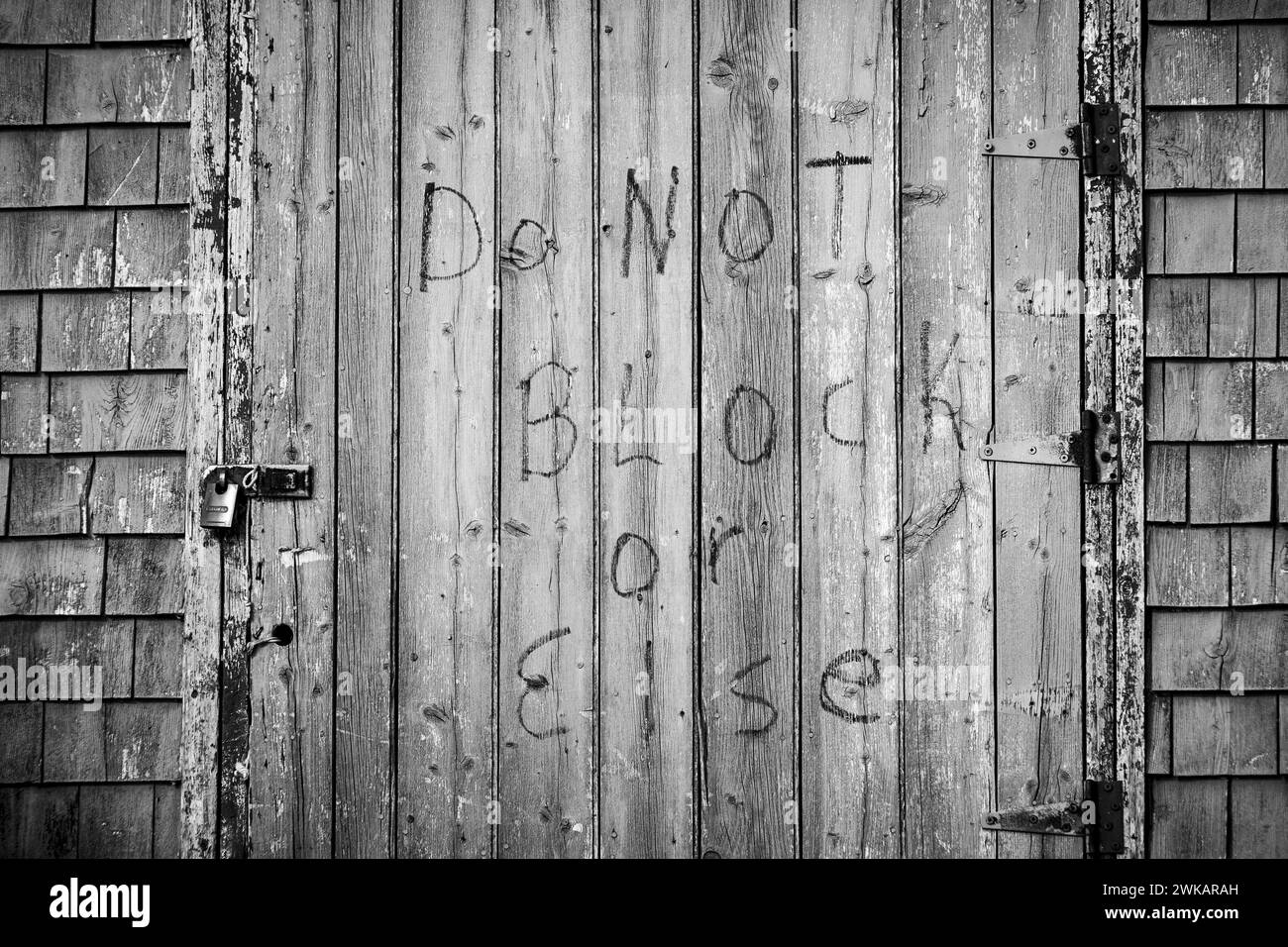 Locked shed door bearing the threat 'Do not block or else'. Stock Photo