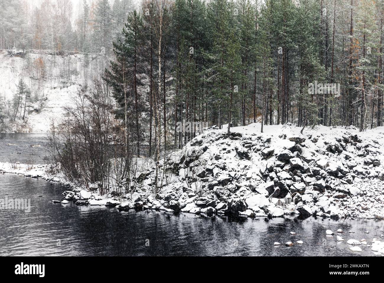 Snowy coasts of Suna River on a cold cloudy winter day, landscape photo of Girvas village, Kondopoga District, Republic of Karelia, Russia Stock Photo