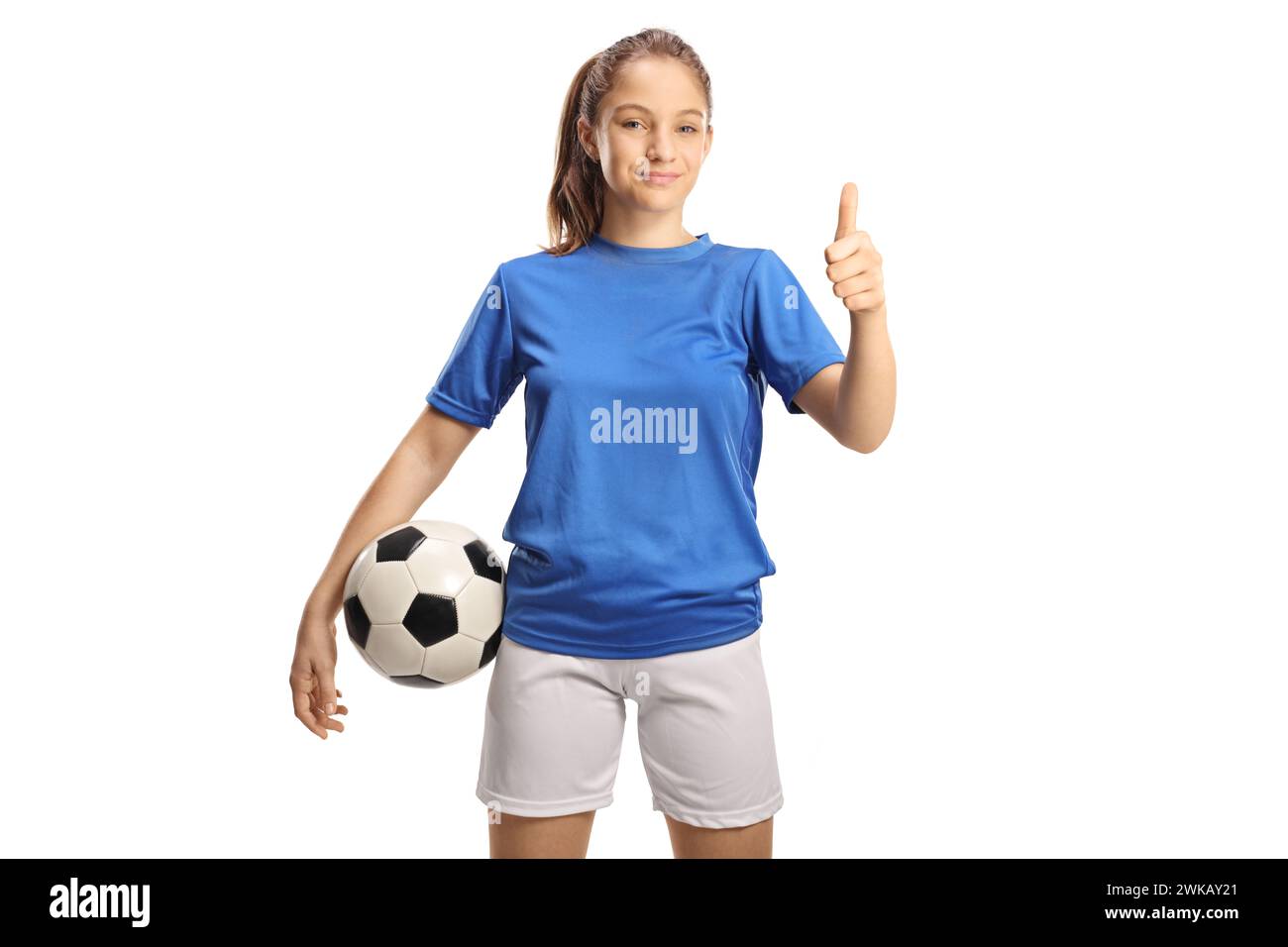 Teenage girl in a football jersey holding a ball and gesturing thumbs up isolated on white background Stock Photo