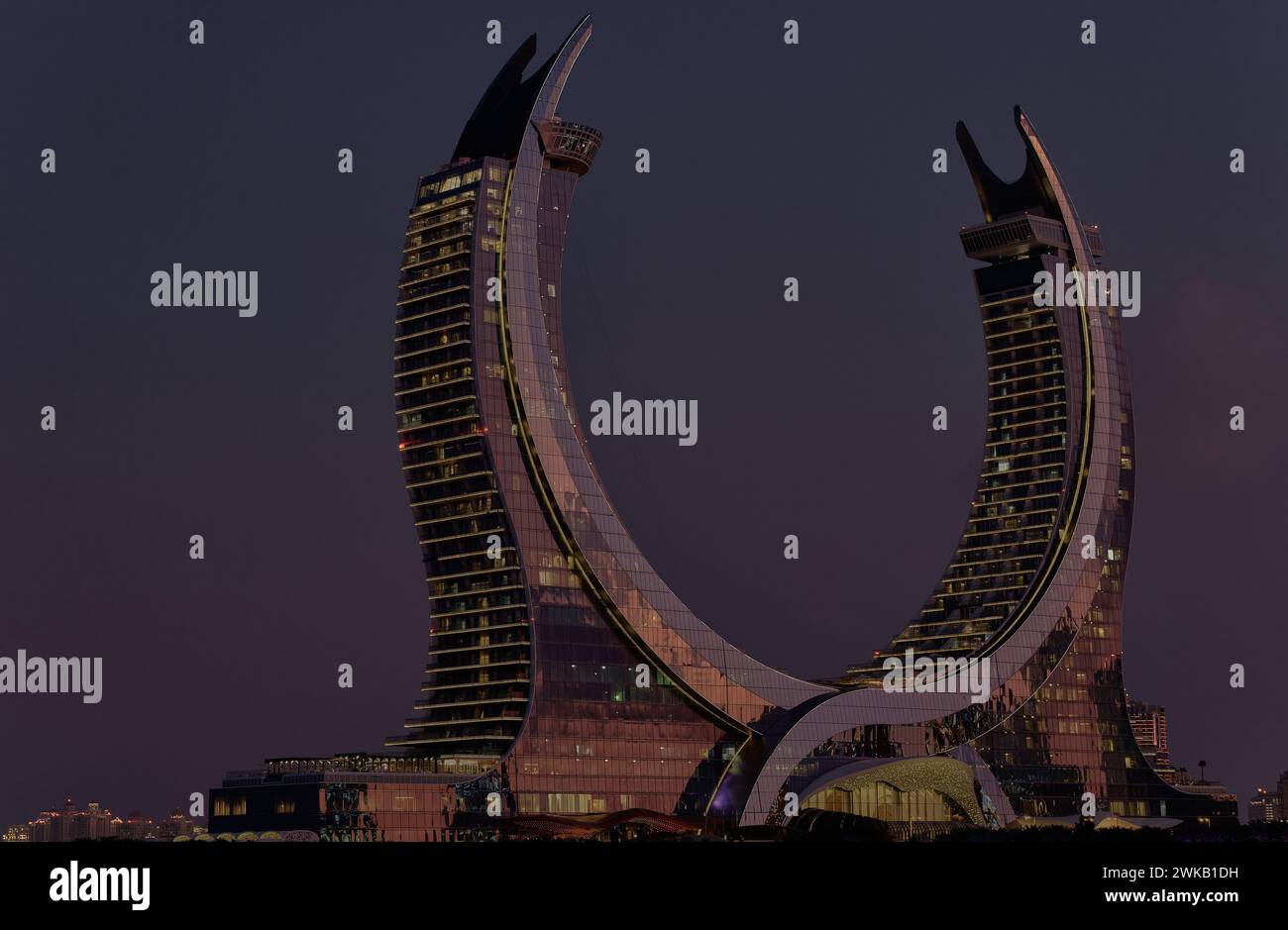 Katara Hospitality Tower, Crescent Tower, in Lusail, Qatar T dusk showing the unique architecture of the illuminated tower Stock Photo