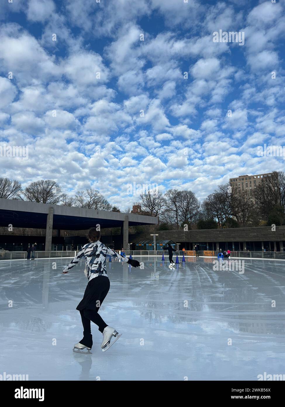 Ice Skaters under a dramatic sky at the rink in Prospect Park, Brooklyn, New York. Stock Photo