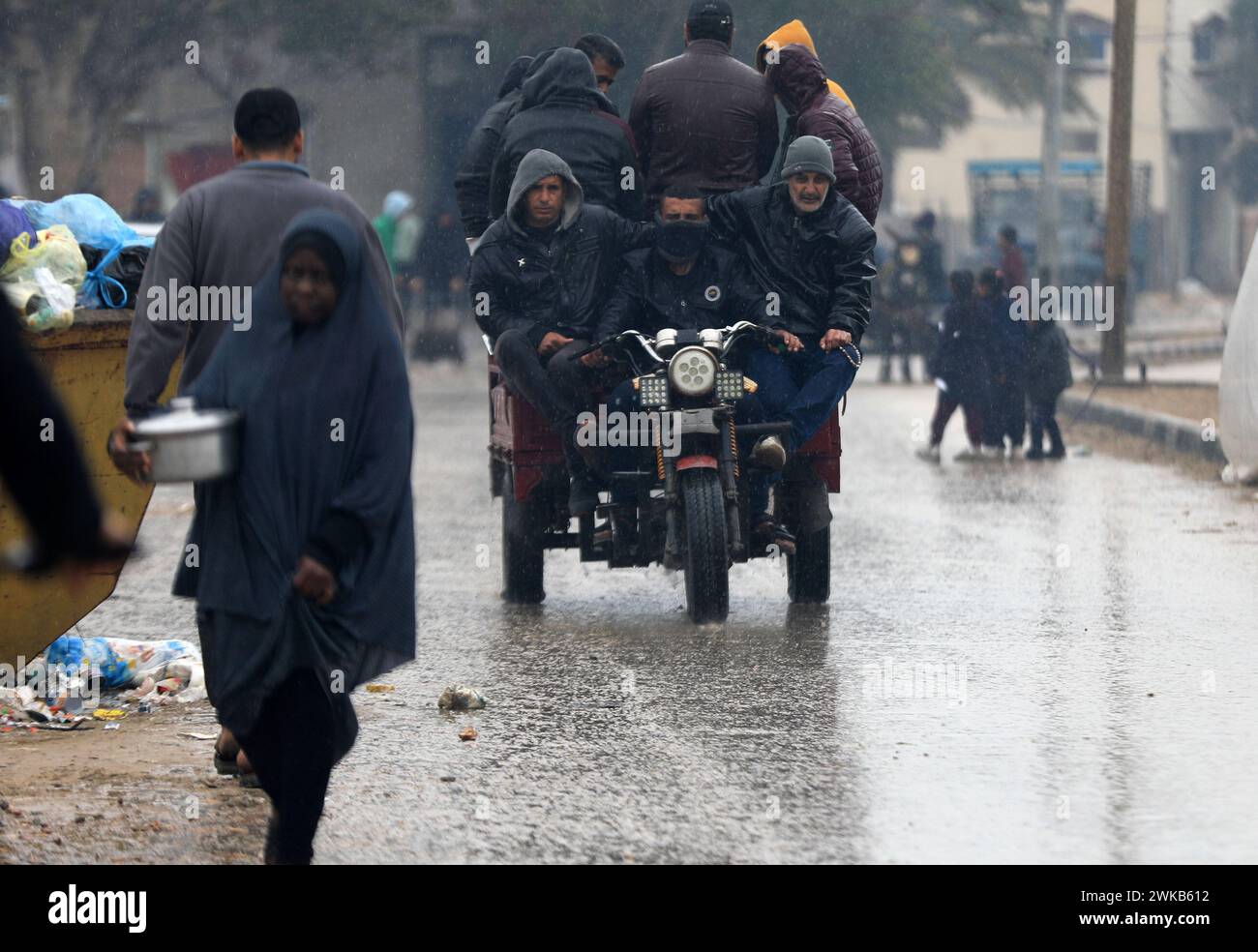 Gaza. 18th Feb, 2024. Palestinian people are seen on a street during a rainy day in the southern Gaza Strip city of Rafah, on Feb. 18, 2024. Over the past few weeks, Israel has signaled its intention to conduct a ground operation in Rafah, Gaza's southernmost town, to 'eliminate' Hamas and rescue Israeli hostages. The impending invasion has deeply concerned the international community. Several countries have spoken out against it, warning of a humanitarian catastrophe in the coastal enclave. Credit: Yasser Qudih/Xinhua/Alamy Live News Stock Photo