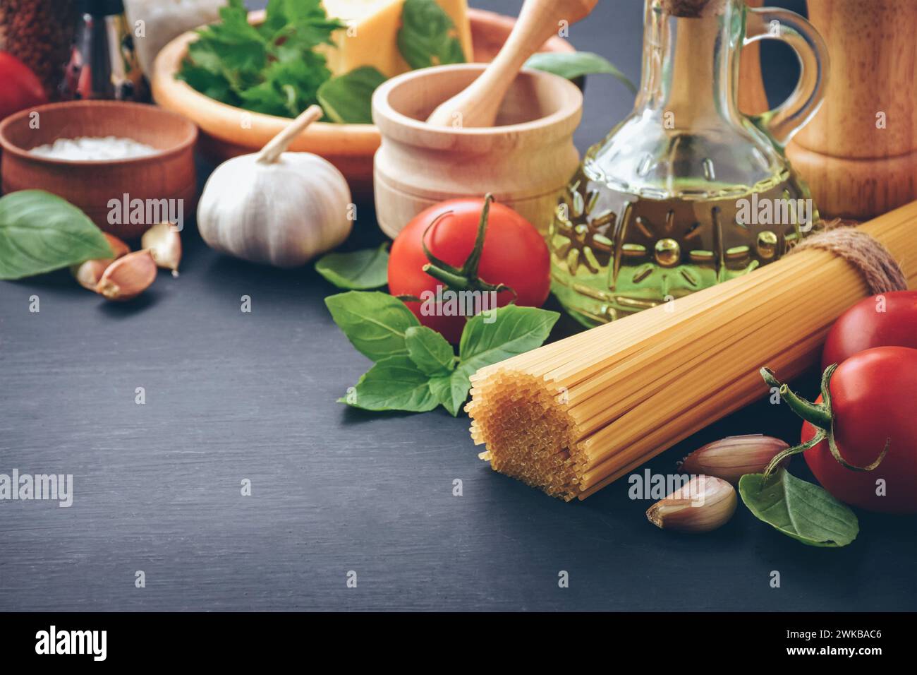 Ingredients for cooking pasta spaghetti alla puttanesca - italian pasta dish with tomatoes, black olives, capers, anchovies and parsley. Stock Photo