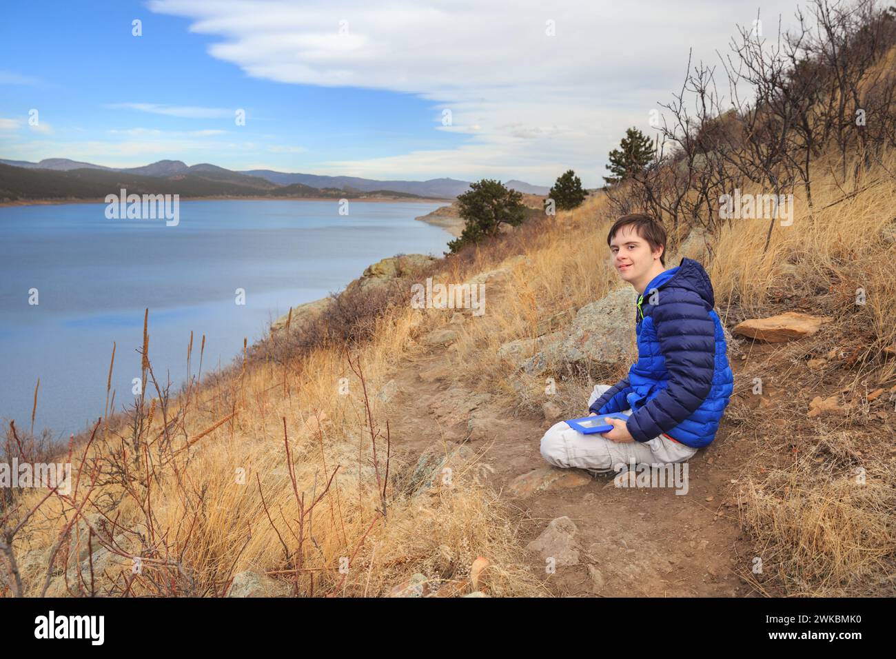 Boy with Special Needs with his tablet at Carter Lake, Colorado, USA