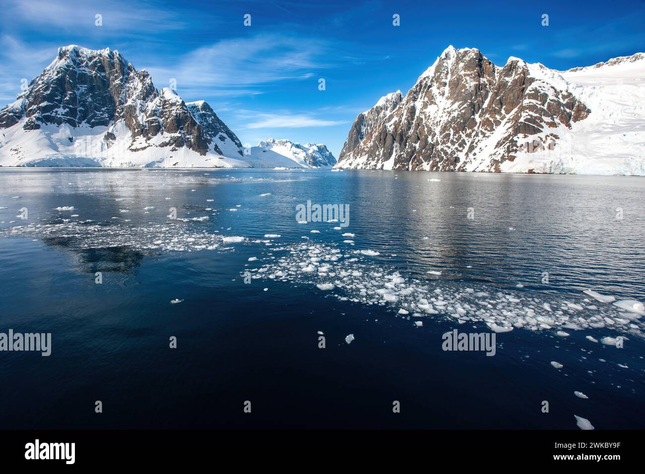 Rugged, towering peaks flanking a fjord in Anders Island off the Antarctic Peninsula, Antartica Stock Photo
