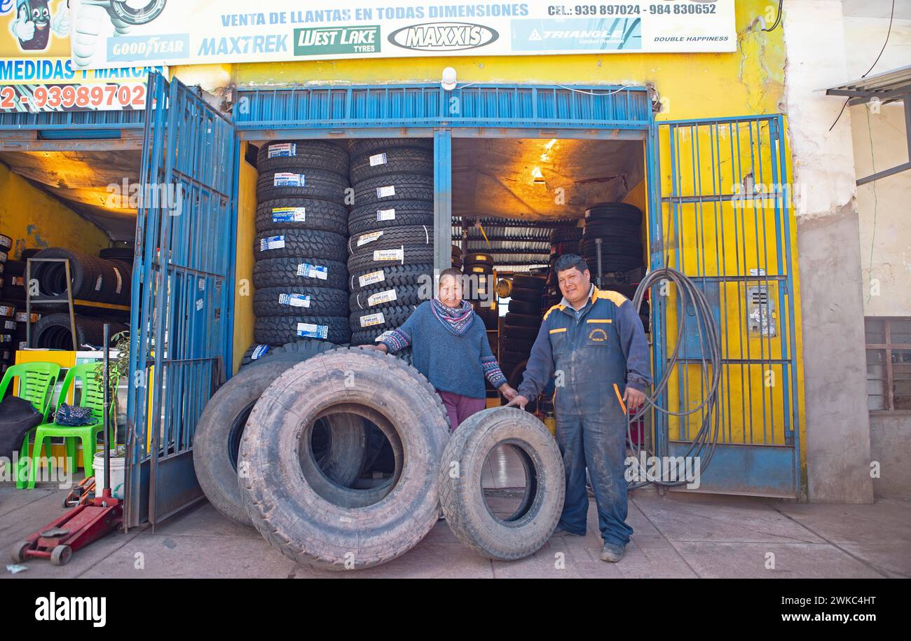 Peruvian couple, 38 and 45 years old, showing tyres from their tyre workshop, Palccoyo, Checacupe district, Canchis province, Cusco region, Peru Stock Photo