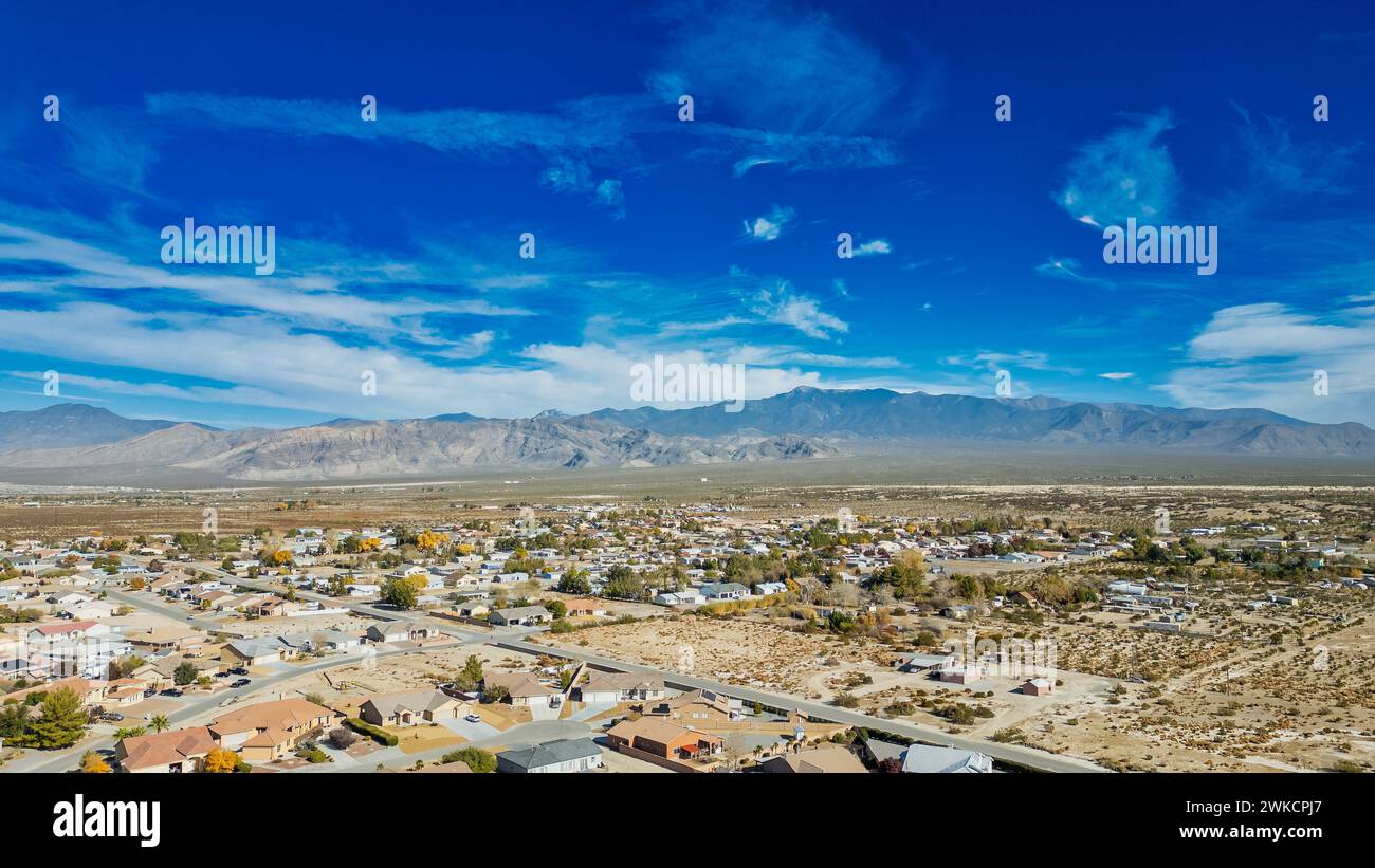 An aerial view of the Pahrump, Nevada desert community with a mix of single-story houses and mobile homes, spread out over a vast, arid landscape. Stock Photo