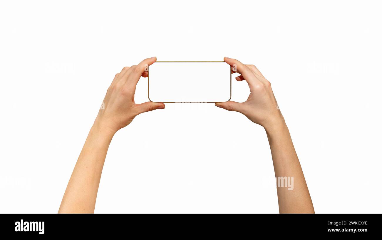 Isolated unrecognisable touchscreen mobile phone with golden yellow frame in female hands, horizontal screen position. Stock Photo