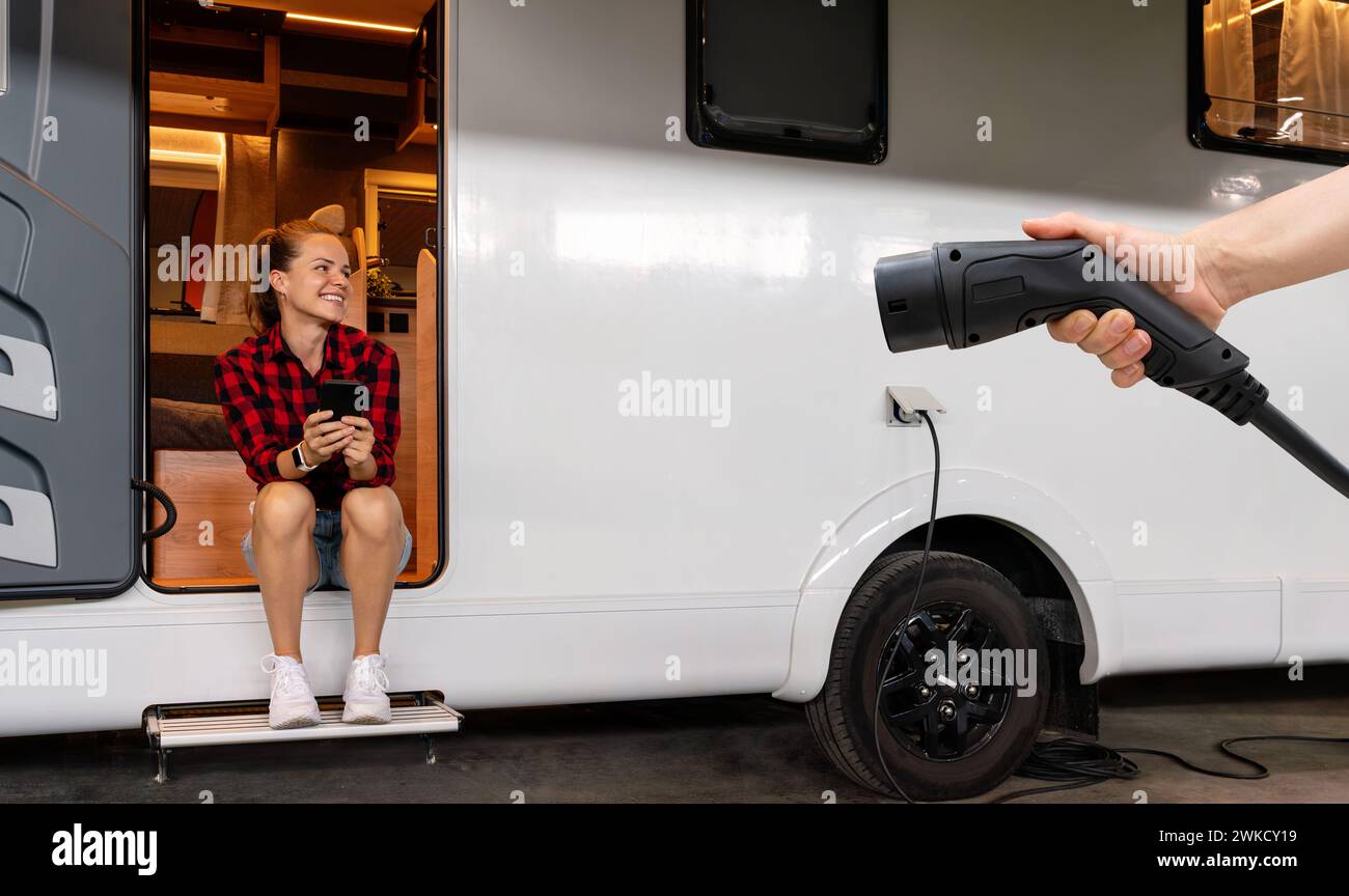 RV powered electric energy concept. Electric plug connector in hand in