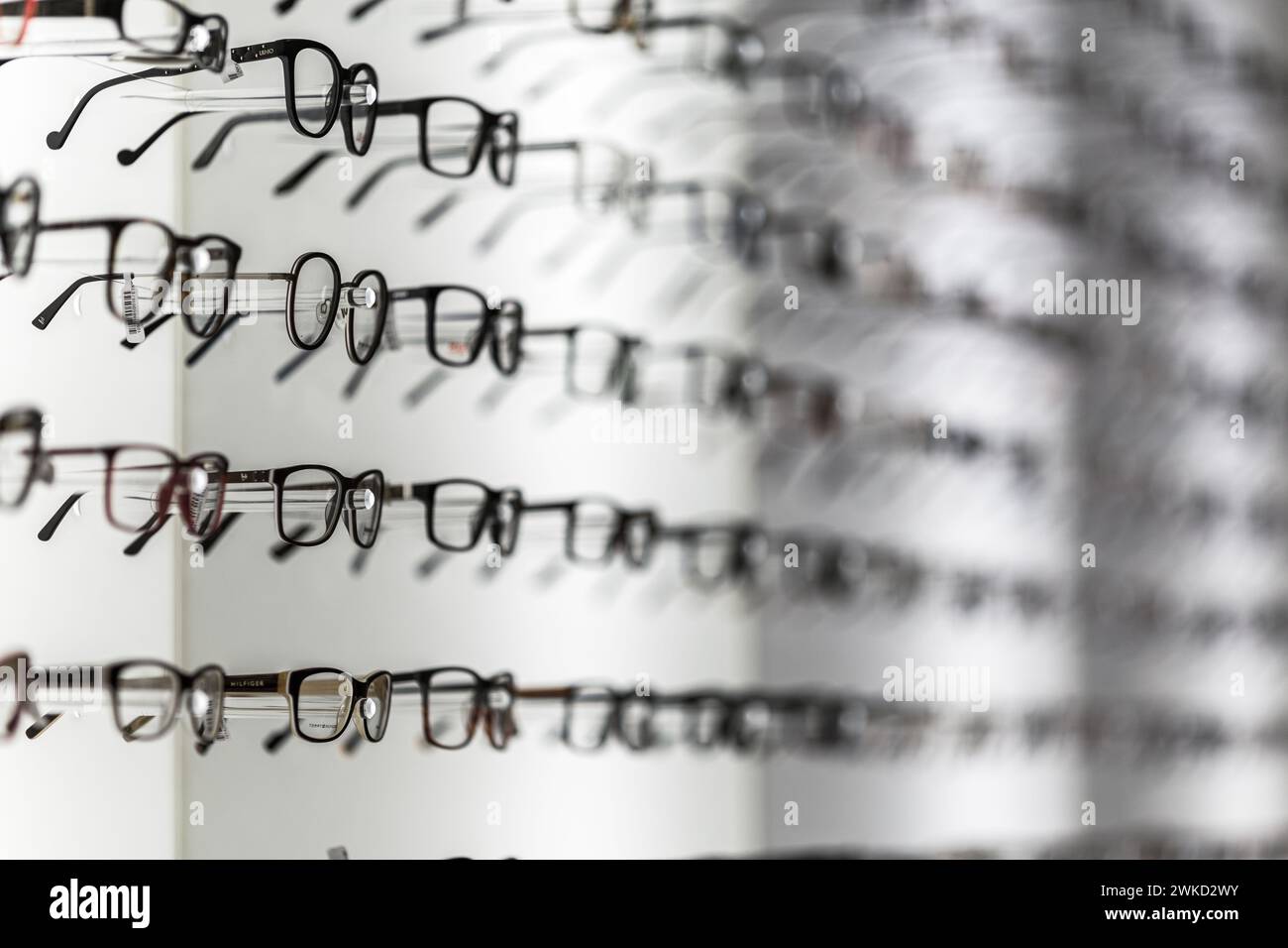 Stylish, modern sunglasses and several other eyeglasses in a row on display in a store Stock Photo