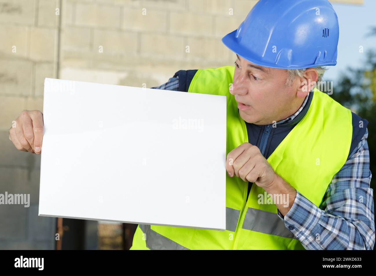 happy builder holding white board Stock Photo