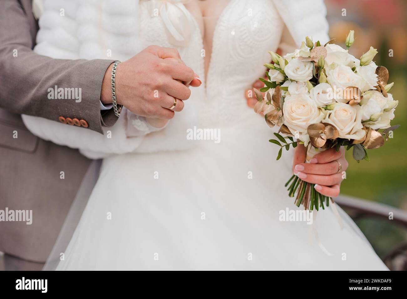 A beautiful wedding bouquet in the hands of the bride. A bouquet with white roses in the hands of the bride Stock Photo