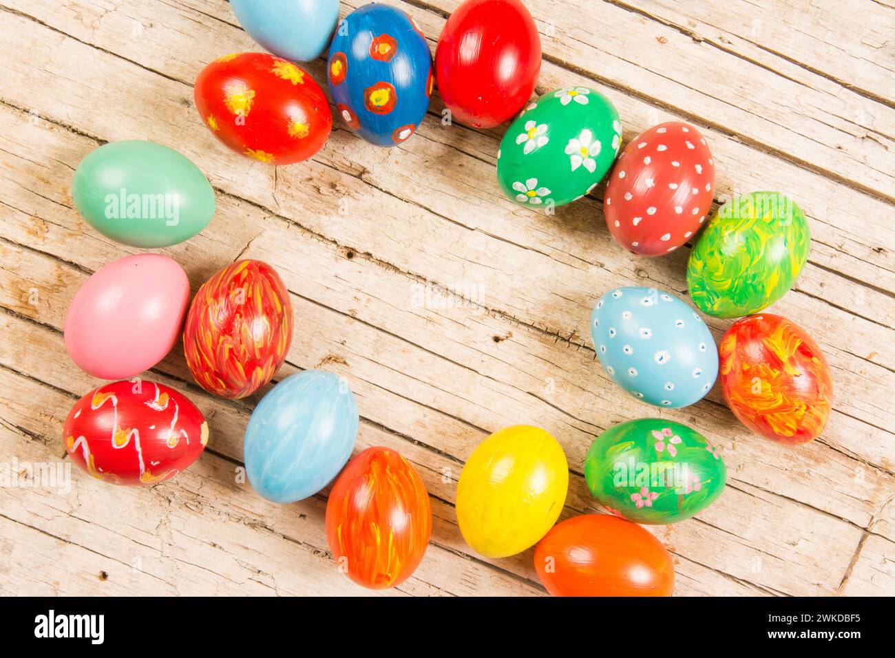 Assorted hand-painted easter eggs on rustic wood backdrop Stock Photo