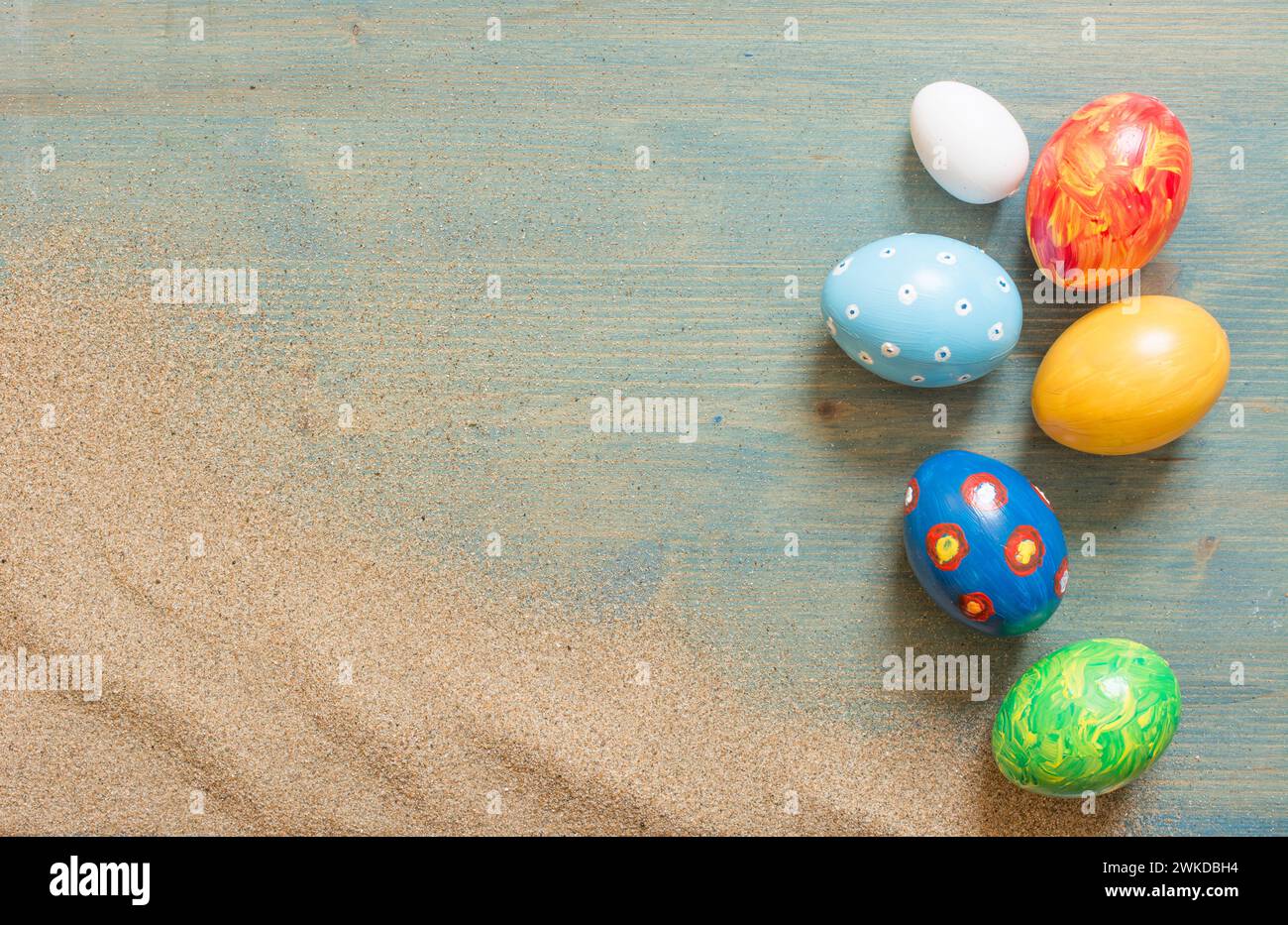 Assorted hand-painted easter eggs on rustic wood backdrop Stock Photo