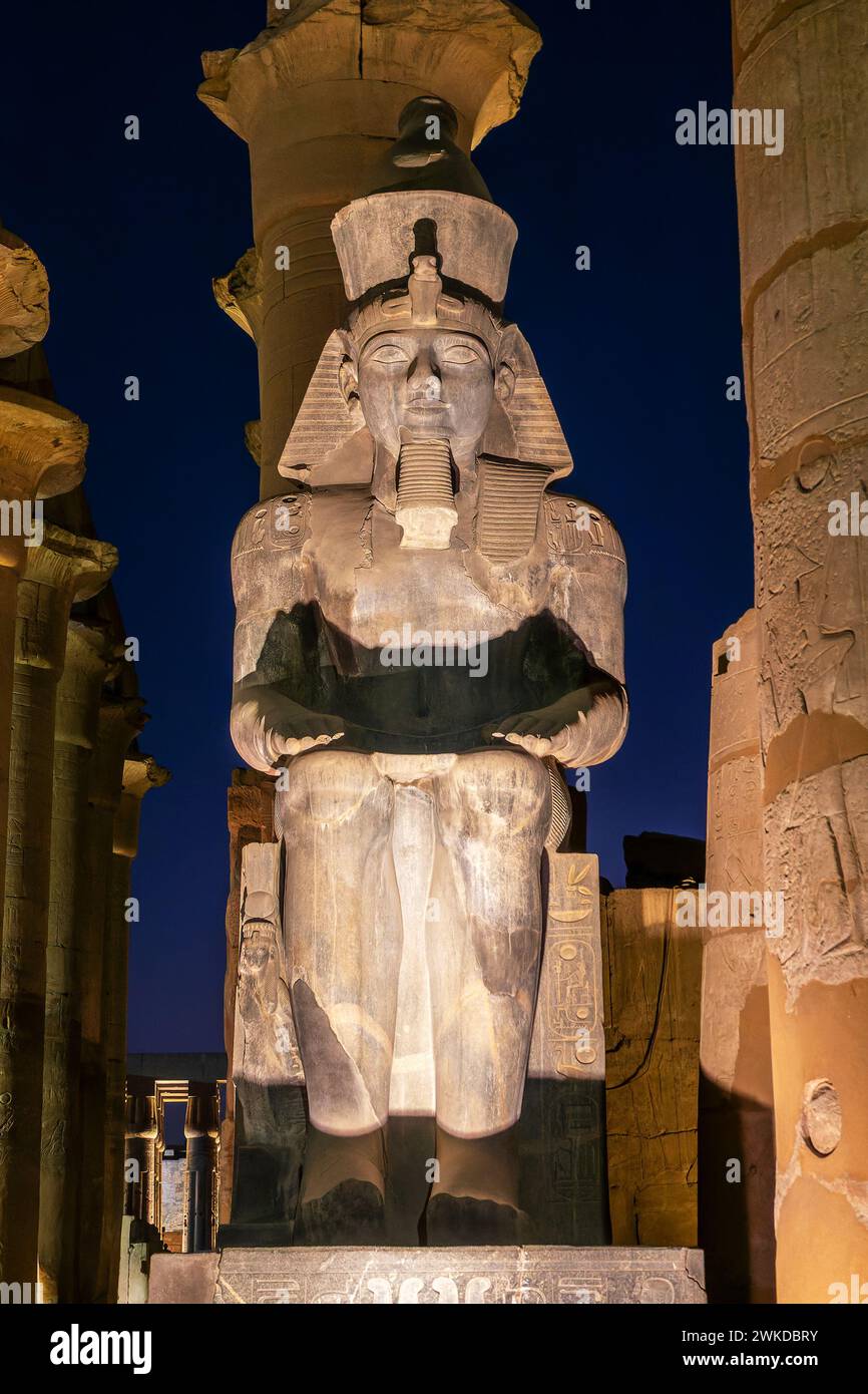 Colossal statue of Ramesses II (Ramses II) in Luxor temple illuminated at night, in Luxor, Egypt Stock Photo