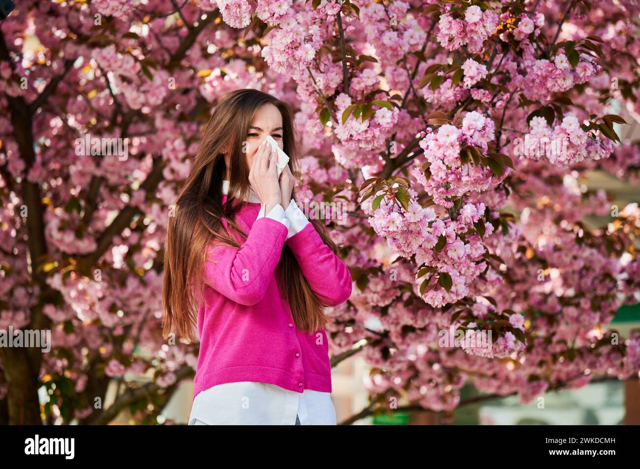 Woman allergic suffering from seasonal allergy at spring in blossoming ...