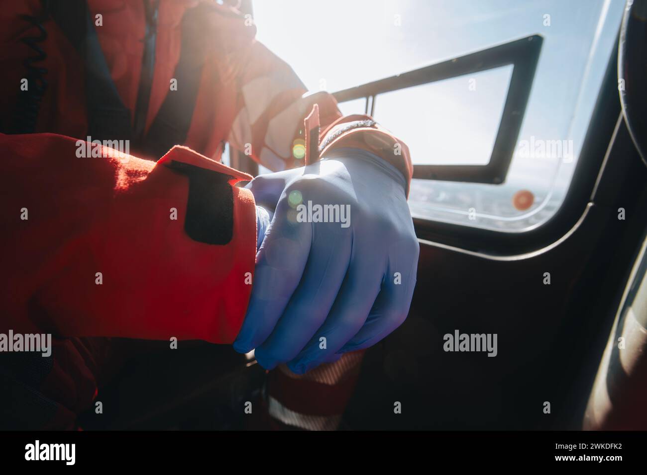 Close-up hands of prepared doctor in surgical gloves inside helicopter of emergency medical service. Themes rescue, help and hope. Stock Photo